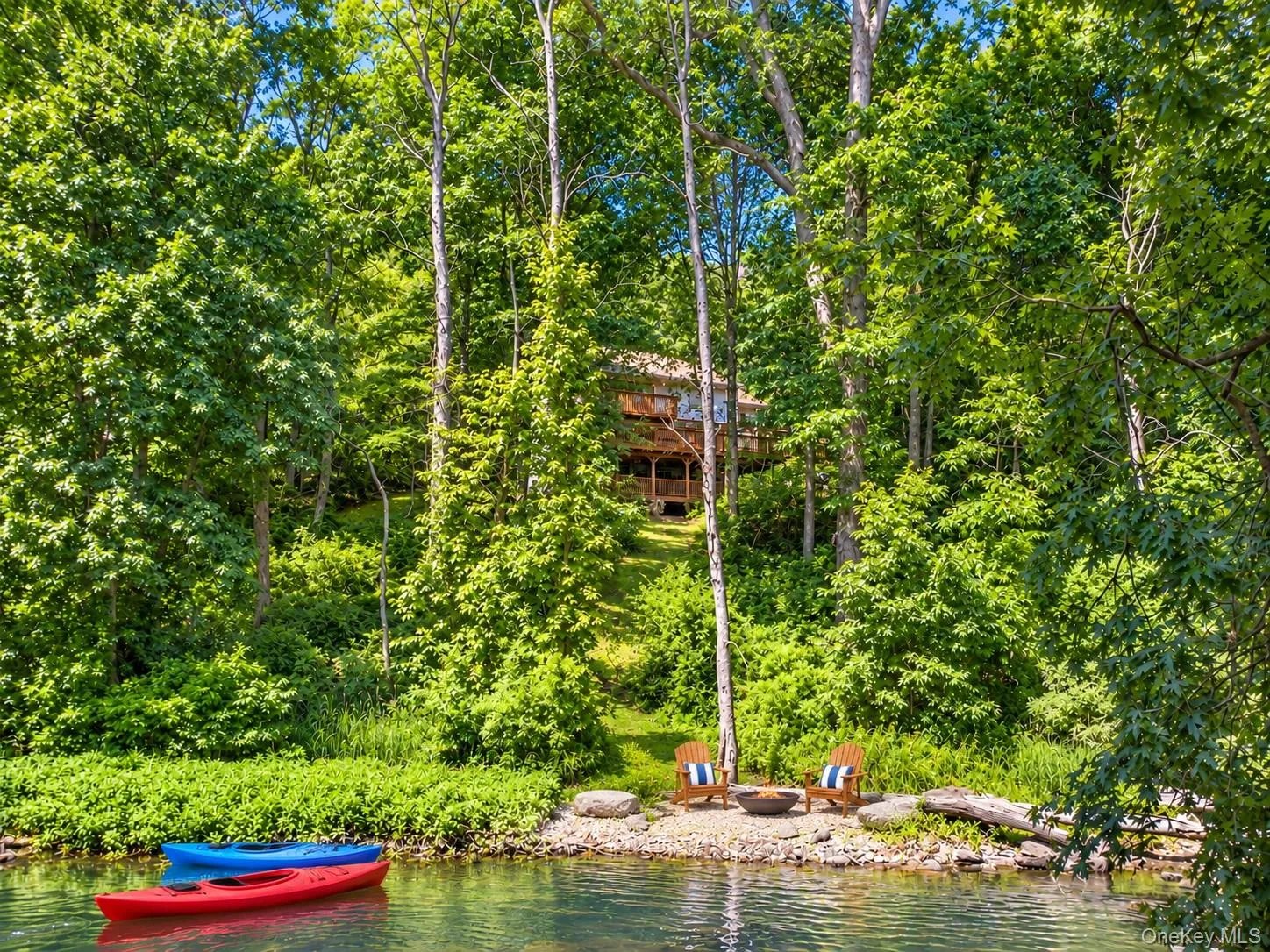 A private pathway leads directly to the river’s edge, where peaceful moments by the water or a leisurely kayak down the river await. A private pathway leads directly to the river’s edge, where peaceful moments by the water or a leisurely kayak down the river await.