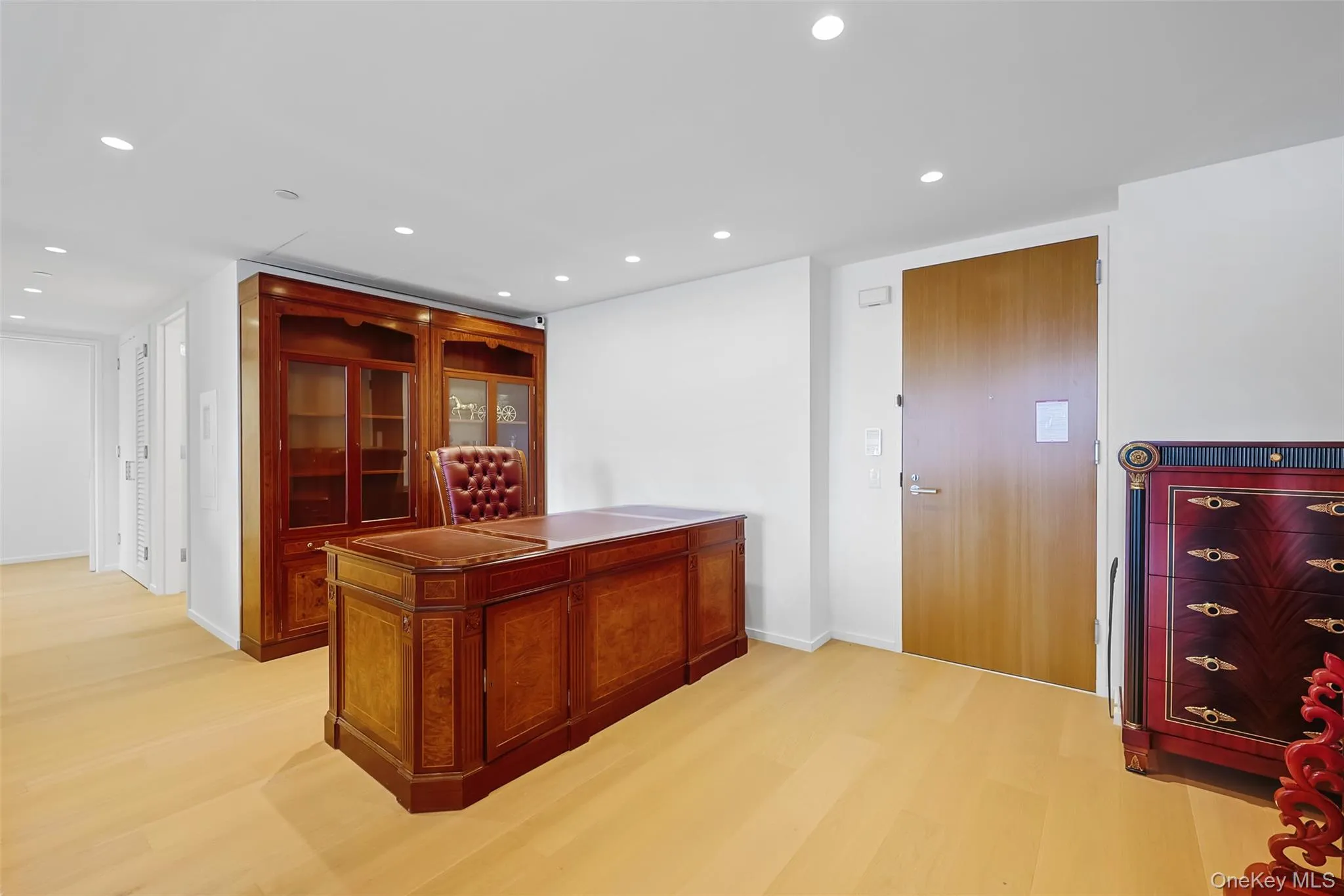 Recessed lighting illuminates wood-finish flooring and a built-in wall unit with glass-front cabinetry Recessed lighting illuminates wood-finish flooring and a built-in wall unit with glass-front cabinetry