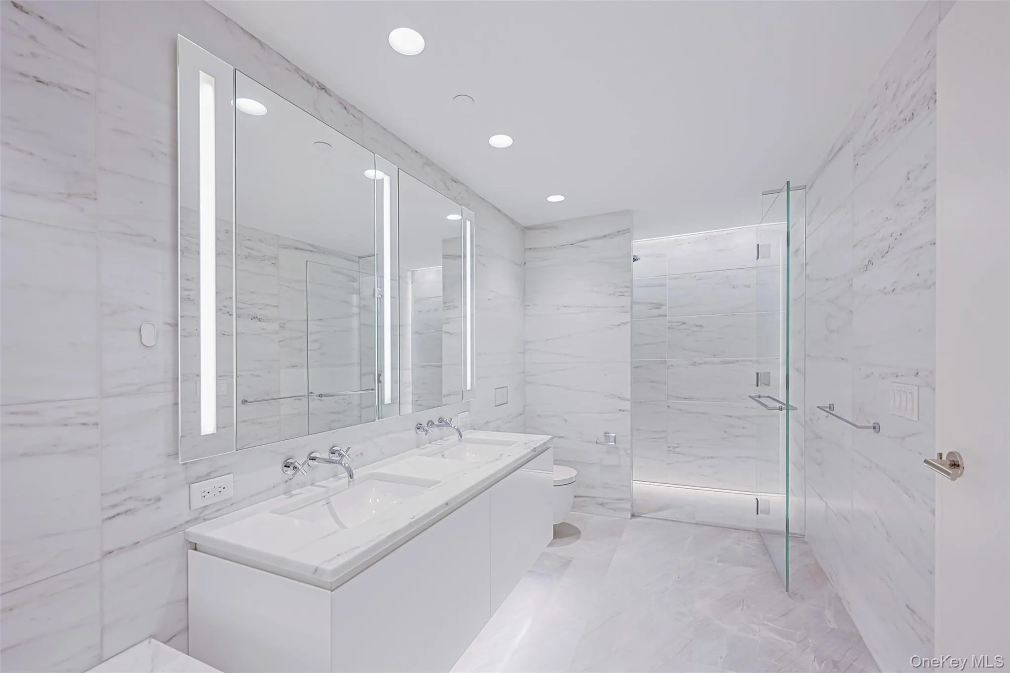 Primary Bathroom Spa-inspired bathrooms feature Blue de Savoie stone floors, Calacatta Lincoln marble walls, oversized walk-in showers, and meticulously crafted custom fixtures and finishes Primary Bathroom Spa-inspired bathrooms feature Blue de Savoie stone floors, Calacatta Lincoln marble walls, oversized walk-in showers, and meticulously crafted custom fixtures and finishes