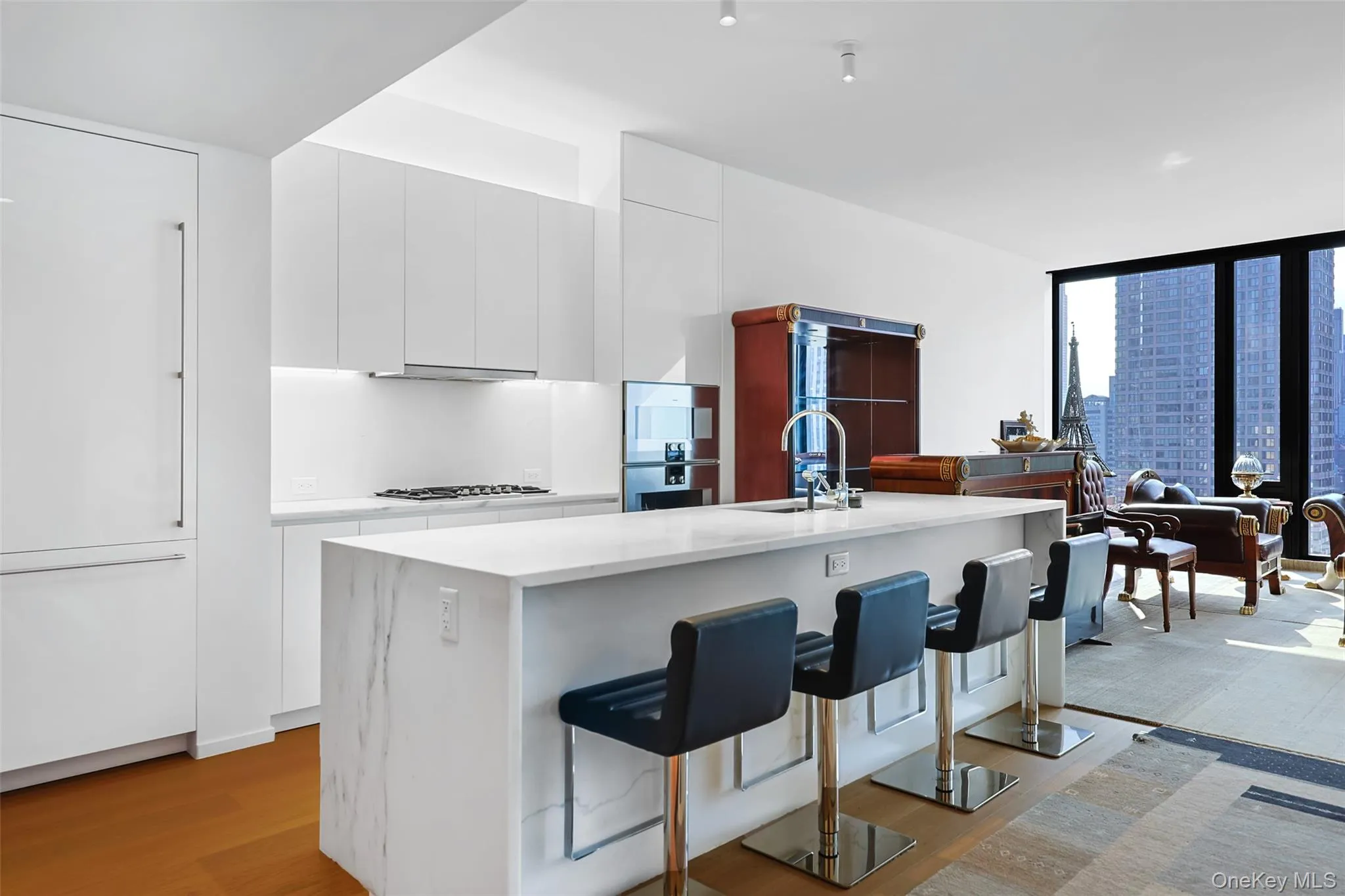 Contemporary kitchen featuring custom Italian white lacquer cabinetry, Calacatta Lincoln marble countertops, natural stone finishes, and a full suite of integrated Gaggenau appliances. Contemporary kitchen featuring custom Italian white lacquer cabinetry, Calacatta Lincoln marble countertops, natural stone finishes, and a full suite of integrated Gaggenau appliances.