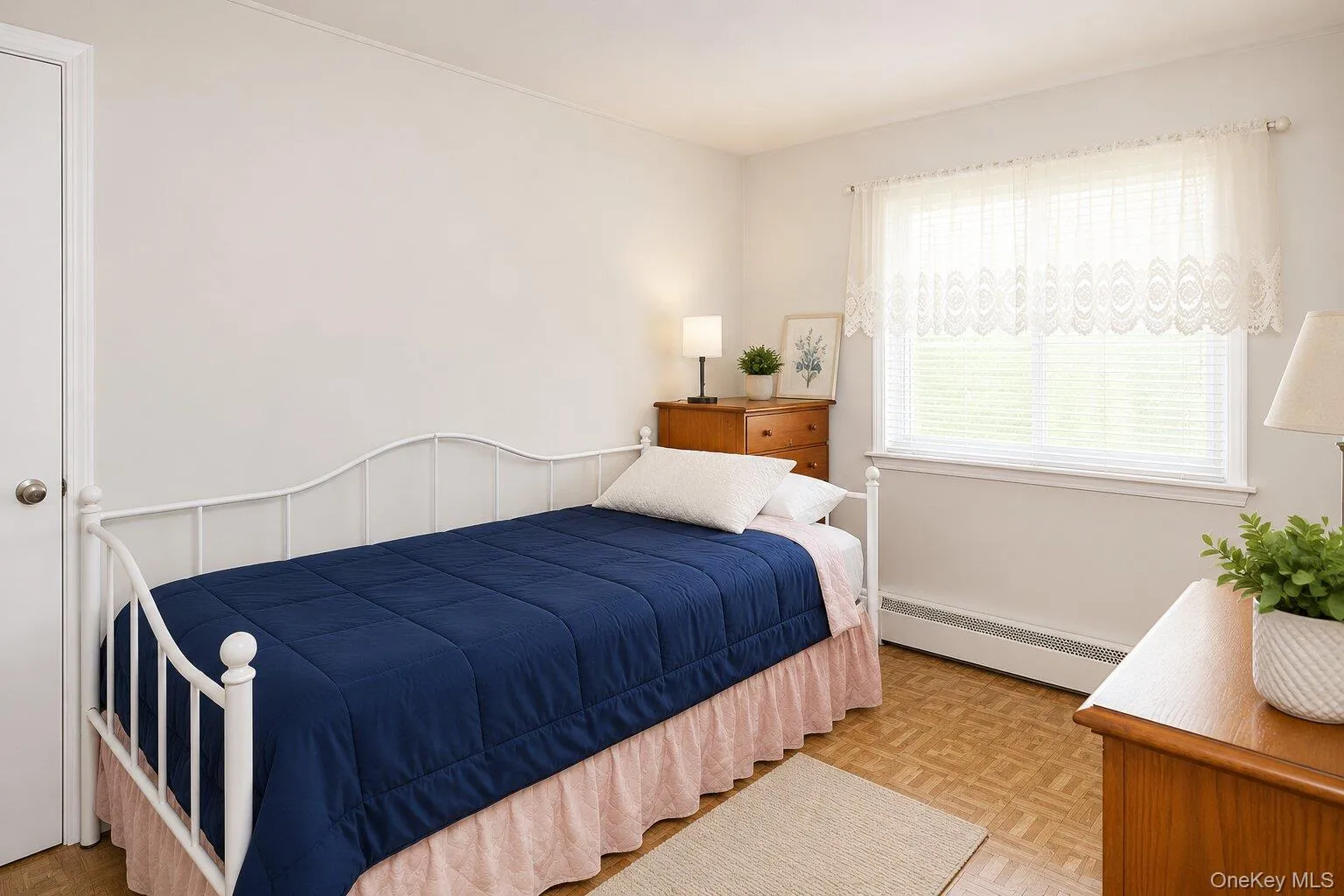 VIRTUALLY STAGED. Room featuring neutral wall tones, patterned wood-finish flooring, and a large window with blinds and valance VIRTUALLY STAGED. Room featuring neutral wall tones, patterned wood-finish flooring, and a large window with blinds and valance