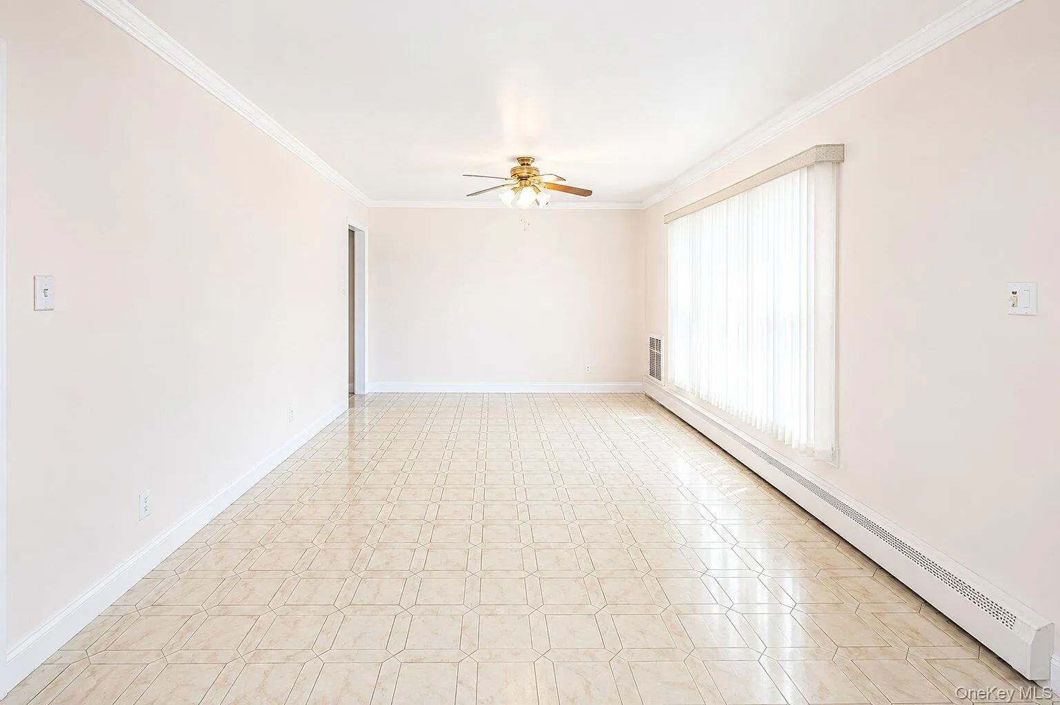 Spacious room featuring geometric pattern tile flooring, crown molding, and a ceiling fan with integrated lighting Spacious room featuring geometric pattern tile flooring, crown molding, and a ceiling fan with integrated lighting