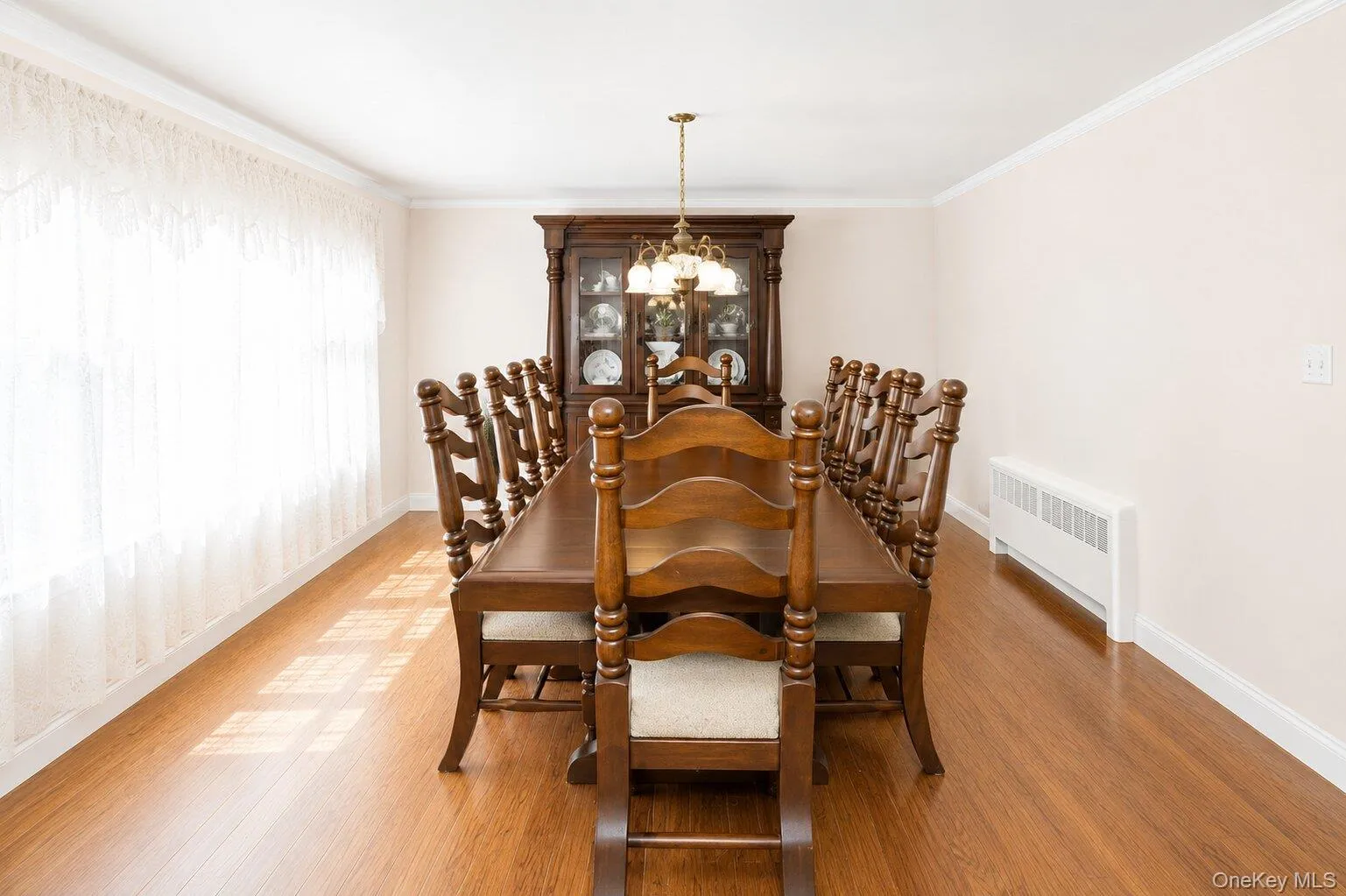 Spacious room featuring wood-finish flooring and crown molding Spacious room featuring wood-finish flooring and crown molding