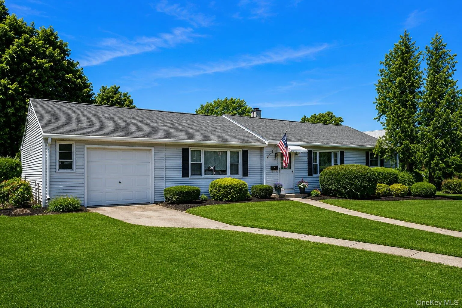 Ranch-style residence featuring light-colored siding and a dark shingle roof Ranch-style residence featuring light-colored siding and a dark shingle roof