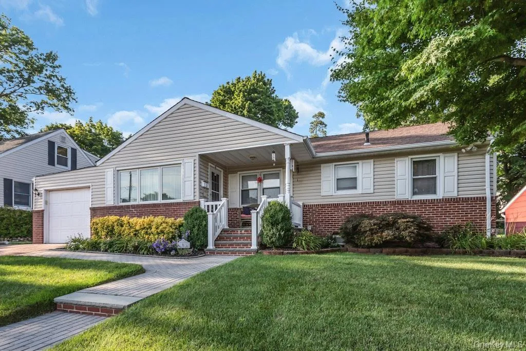 Ranch-style residence featuring a combination of brick and siding, a covered porch entry, an attached garage, and a paver walkway Ranch-style residence featuring a combination of brick and siding, a covered porch entry, an attached garage, and a paver walkway
