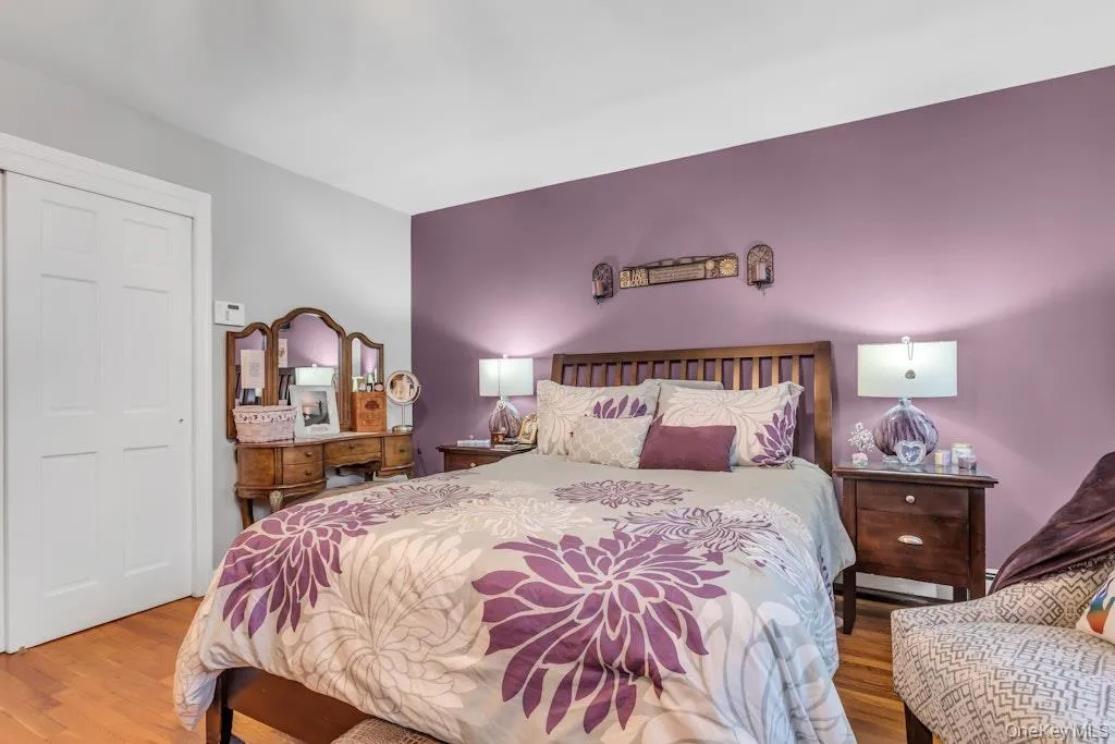 Hardwood-style flooring extends throughout this space, complemented by a two-panel closet door and a decorative wall sconce Hardwood-style flooring extends throughout this space, complemented by a two-panel closet door and a decorative wall sconce