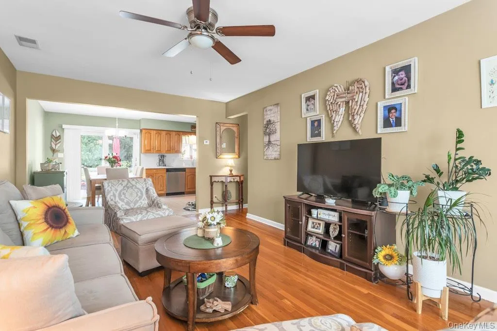 Living space featuring wood-finish flooring and a ceiling fan Living space featuring wood-finish flooring and a ceiling fan