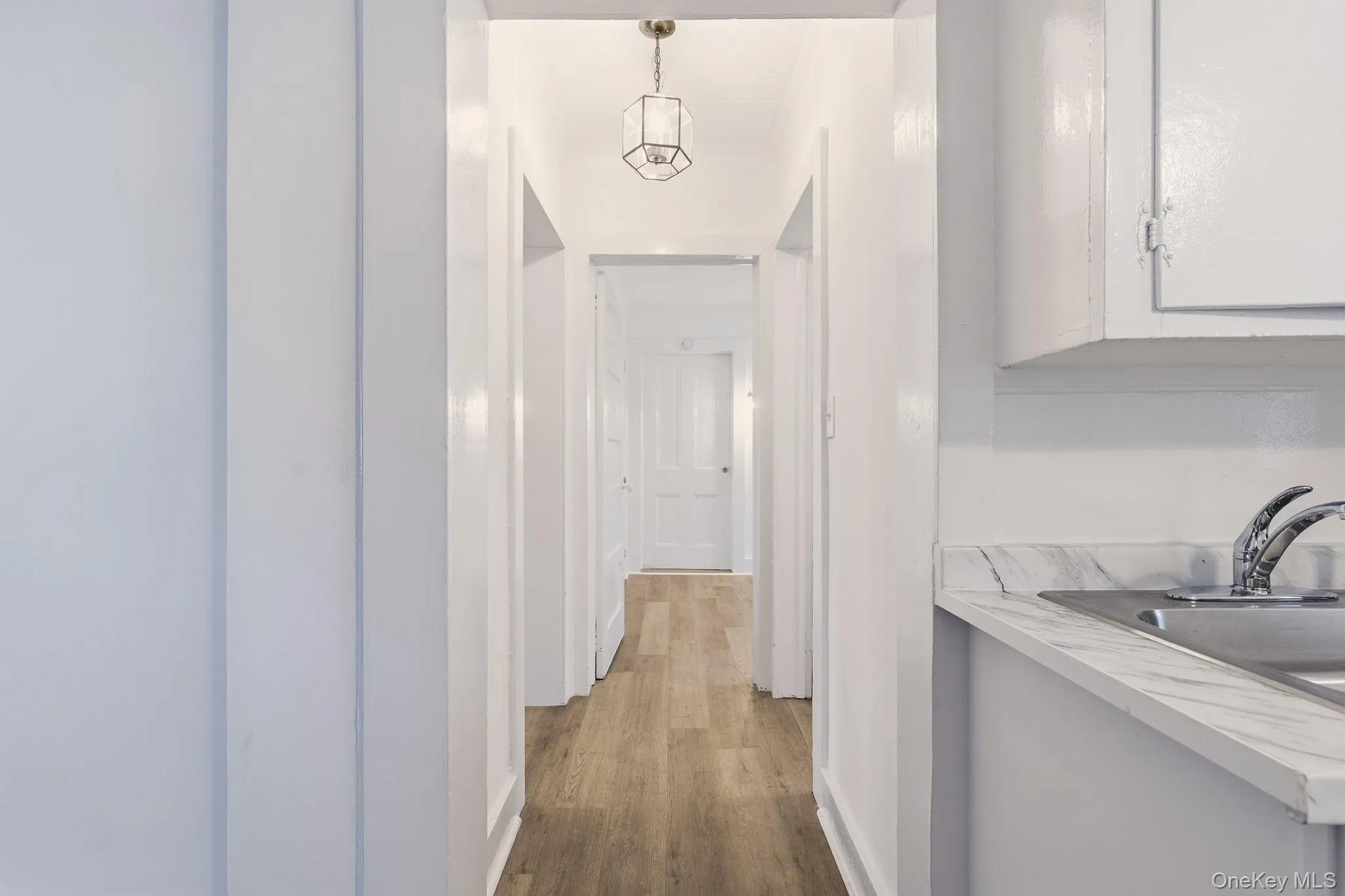 The hallway runs through the home from front to back with beautiful wood floors and bright white paint. The hallway runs through the home from front to back with beautiful wood floors and bright white paint.