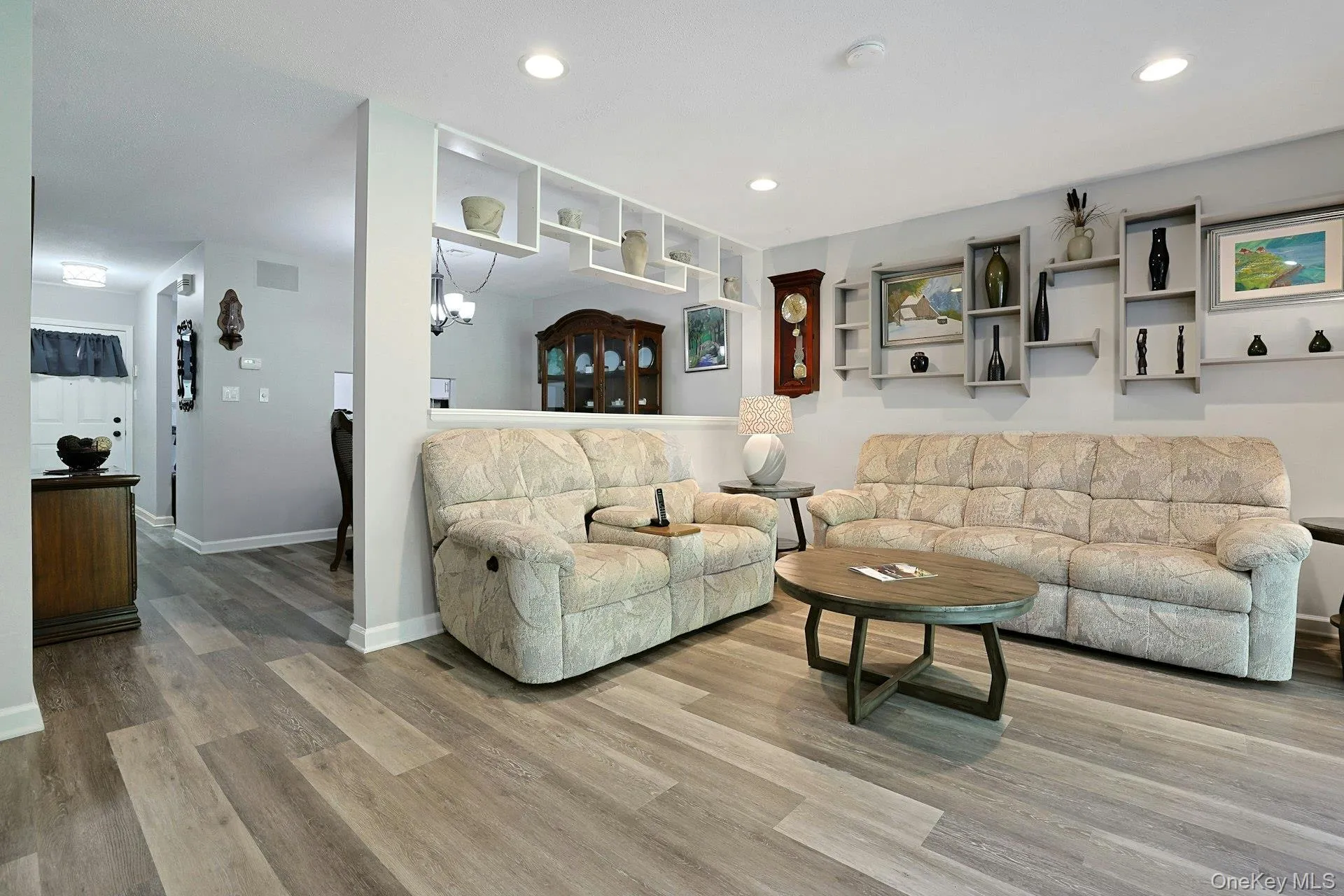 the living room is spacious and has custom shelving and new wood-finish flooring the living room is spacious and has custom shelving and new wood-finish flooring