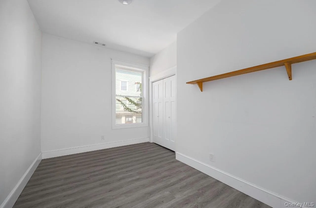 Unfurnished bedroom with dark wood finished floors and a closet Unfurnished bedroom with dark wood finished floors and a closet