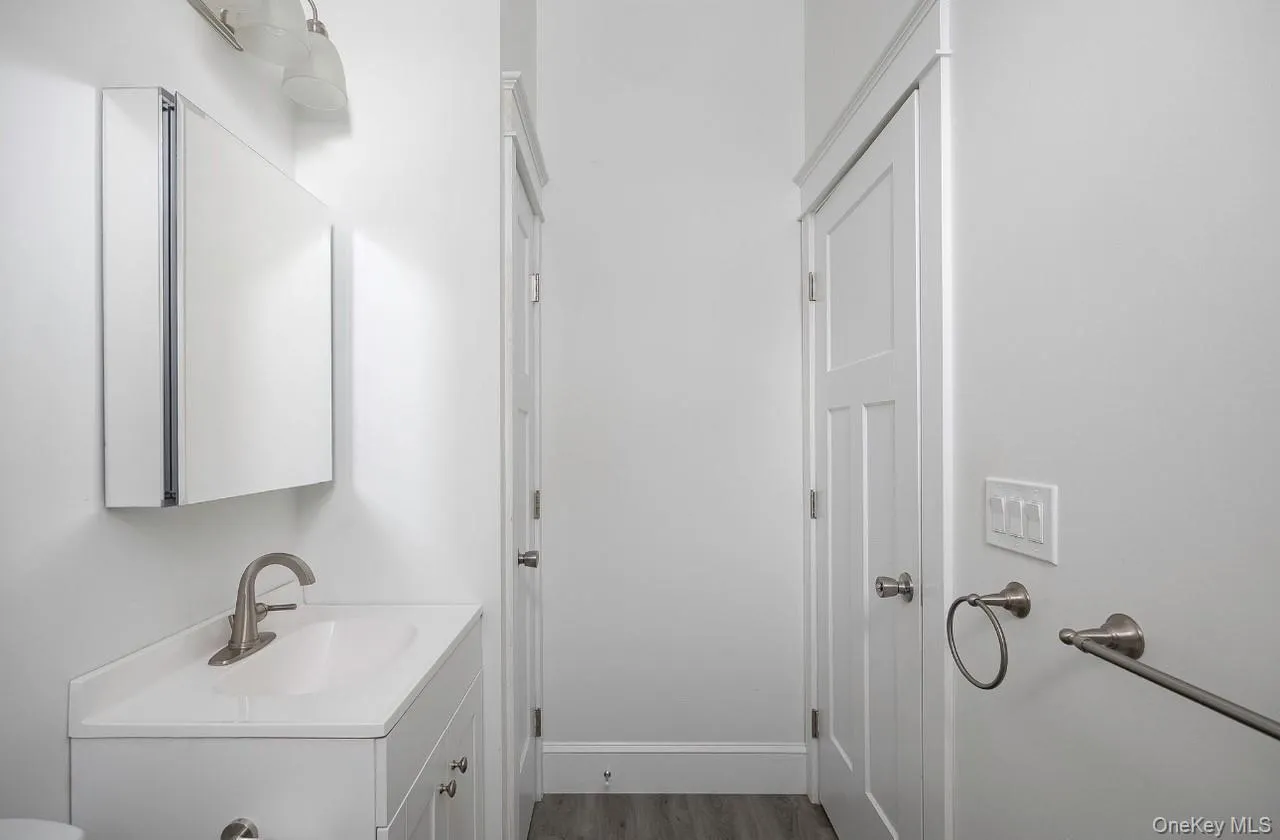 Half bath with dark wood-style flooring and vanity Half bath with dark wood-style flooring and vanity