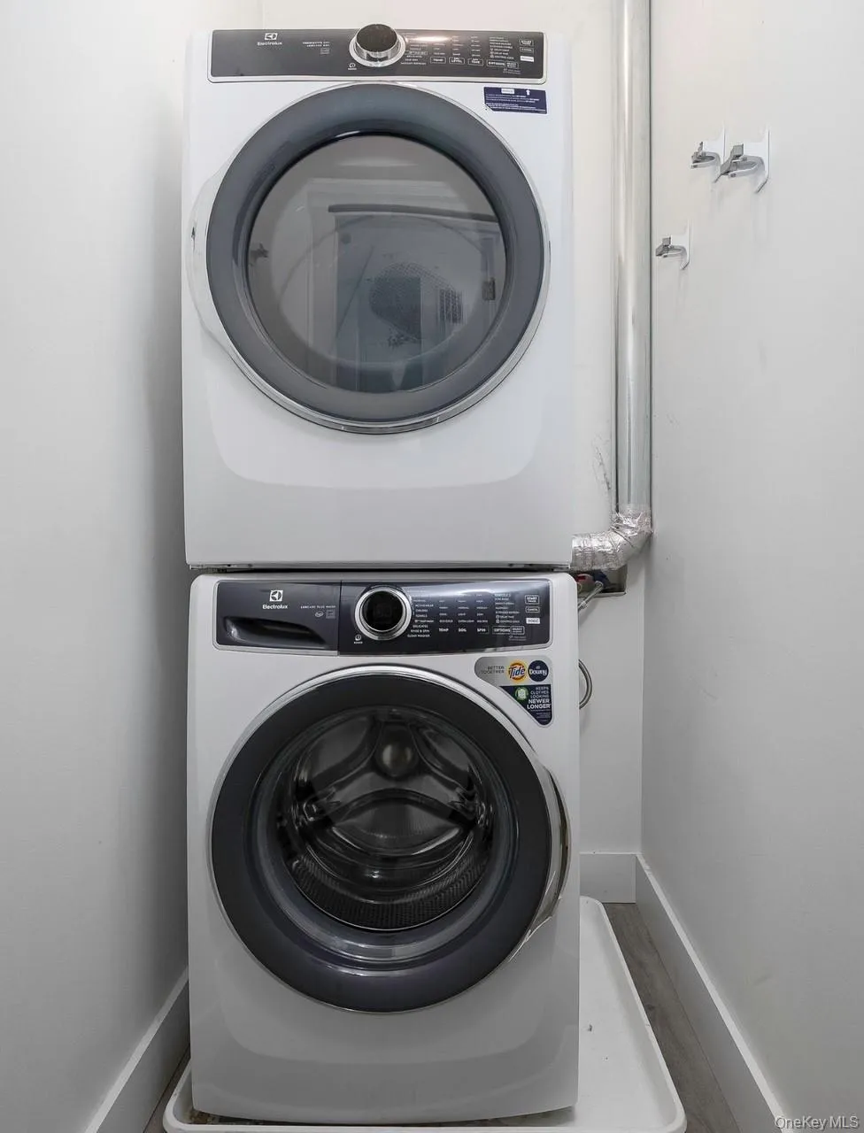 Laundry area with stacked washer / dryer and baseboards Laundry area with stacked washer / dryer and baseboards