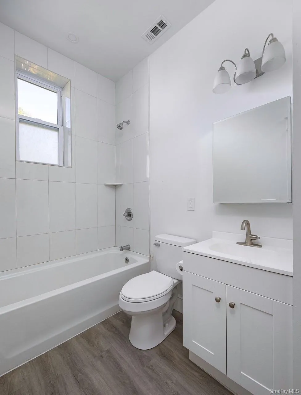 Bathroom with shower combination, vanity, and wood finished floors Bathroom with shower combination, vanity, and wood finished floors