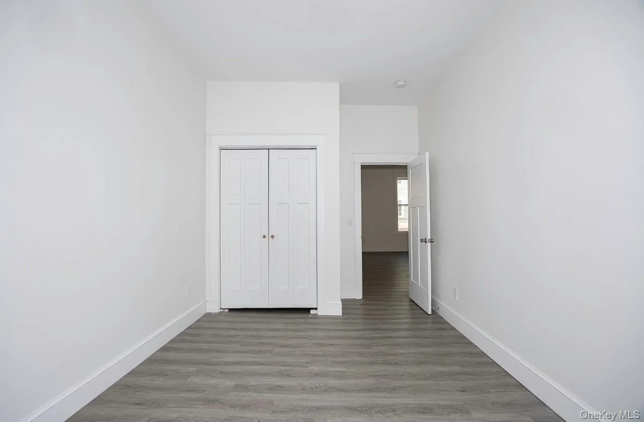 Unfurnished bedroom featuring wood finished floors and a closet Unfurnished bedroom featuring wood finished floors and a closet