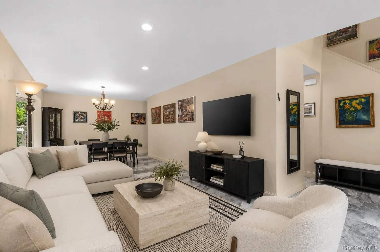 Open concept living and dining area featuring recessed lighting, a contemporary chandelier, light-toned walls, and stone-finish flooring Open concept living and dining area featuring recessed lighting, a contemporary chandelier, light-toned walls, and stone-finish flooring