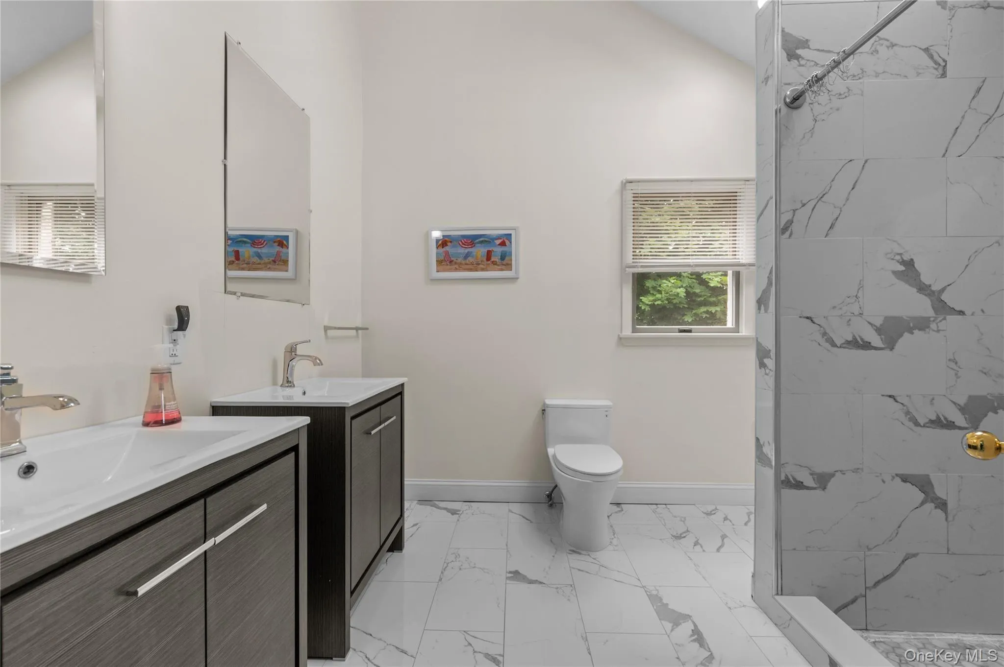 Bathroom featuring a dual vanity with undermount sinks, tiles and a walk-in shower Bathroom featuring a dual vanity with undermount sinks, tiles and a walk-in shower