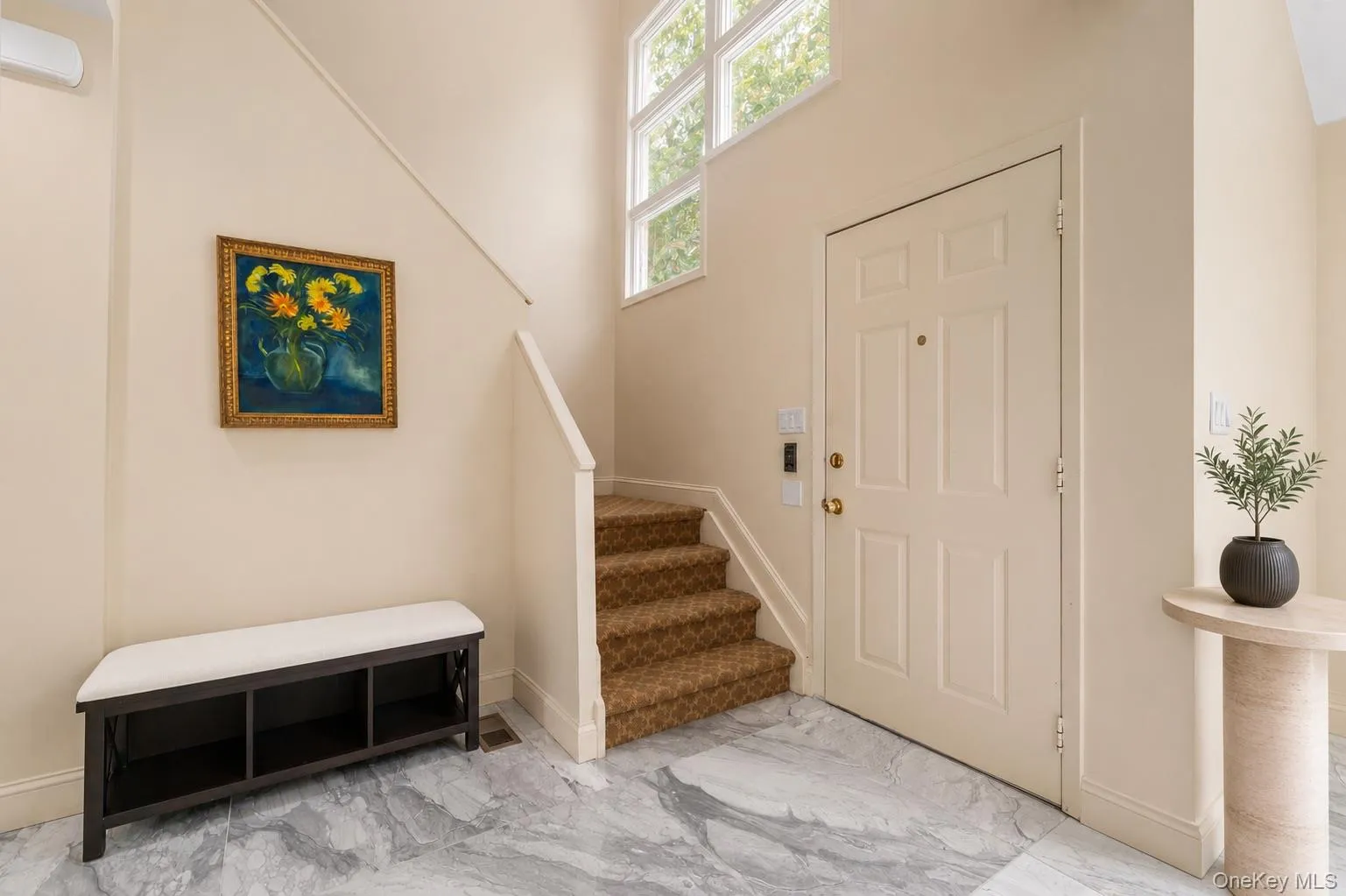 Foyer featuring a paneled entry door, high ceilings, windows, and light-toned walls Foyer featuring a paneled entry door, high ceilings, windows, and light-toned walls