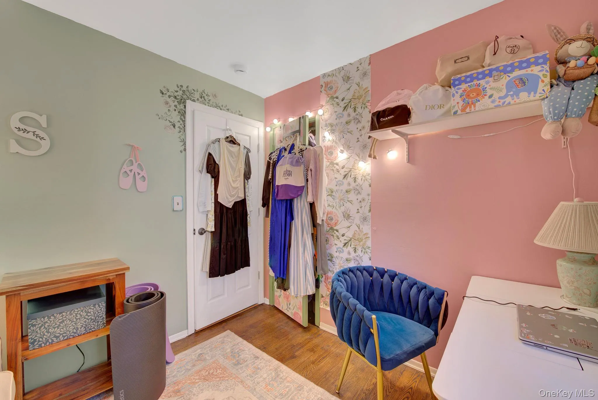 Room featuring a multi-toned wall design with a floral accent wall Room featuring a multi-toned wall design with a floral accent wall