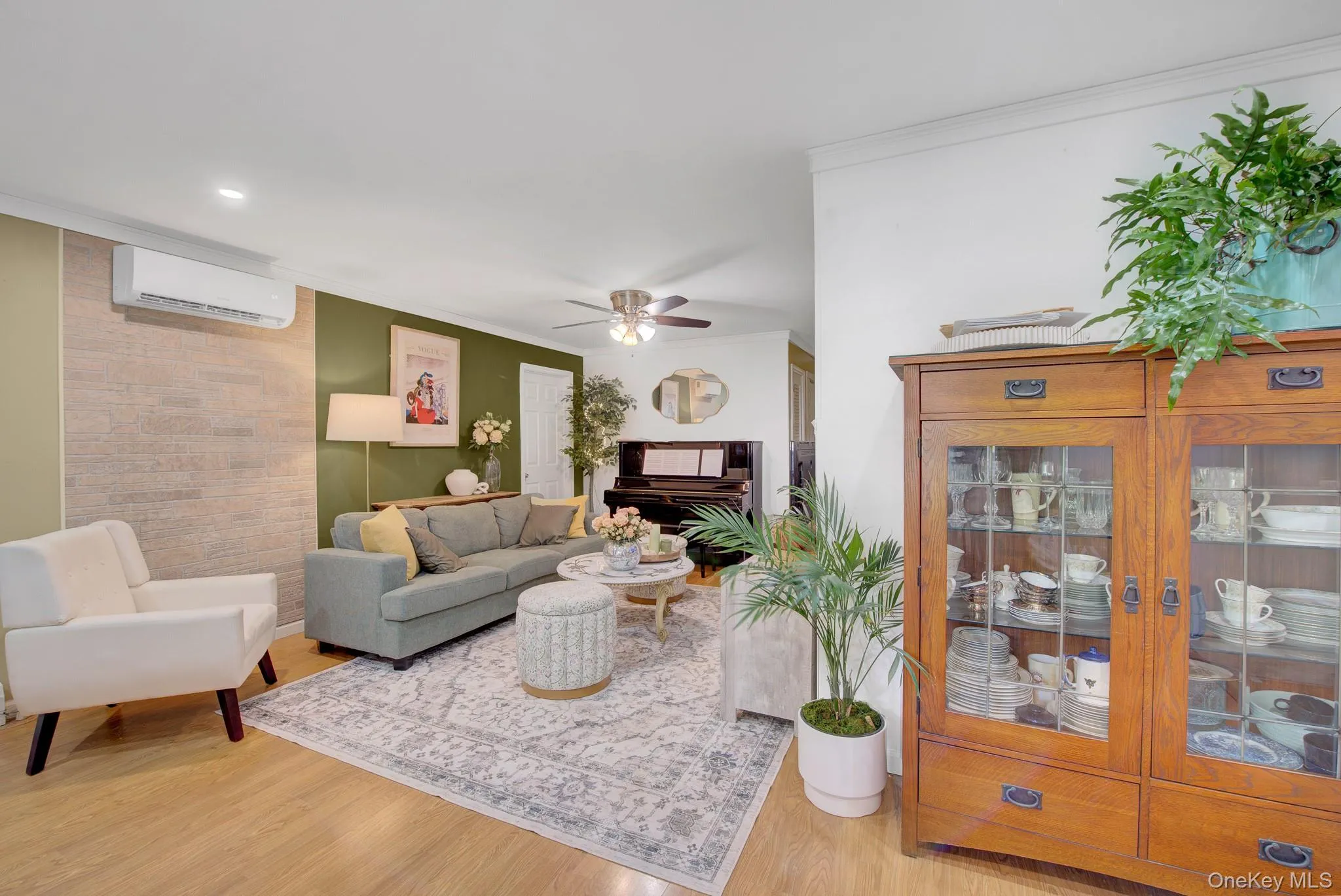 Living area featuring wood-finish flooring and a decorative accent wall Living area featuring wood-finish flooring and a decorative accent wall