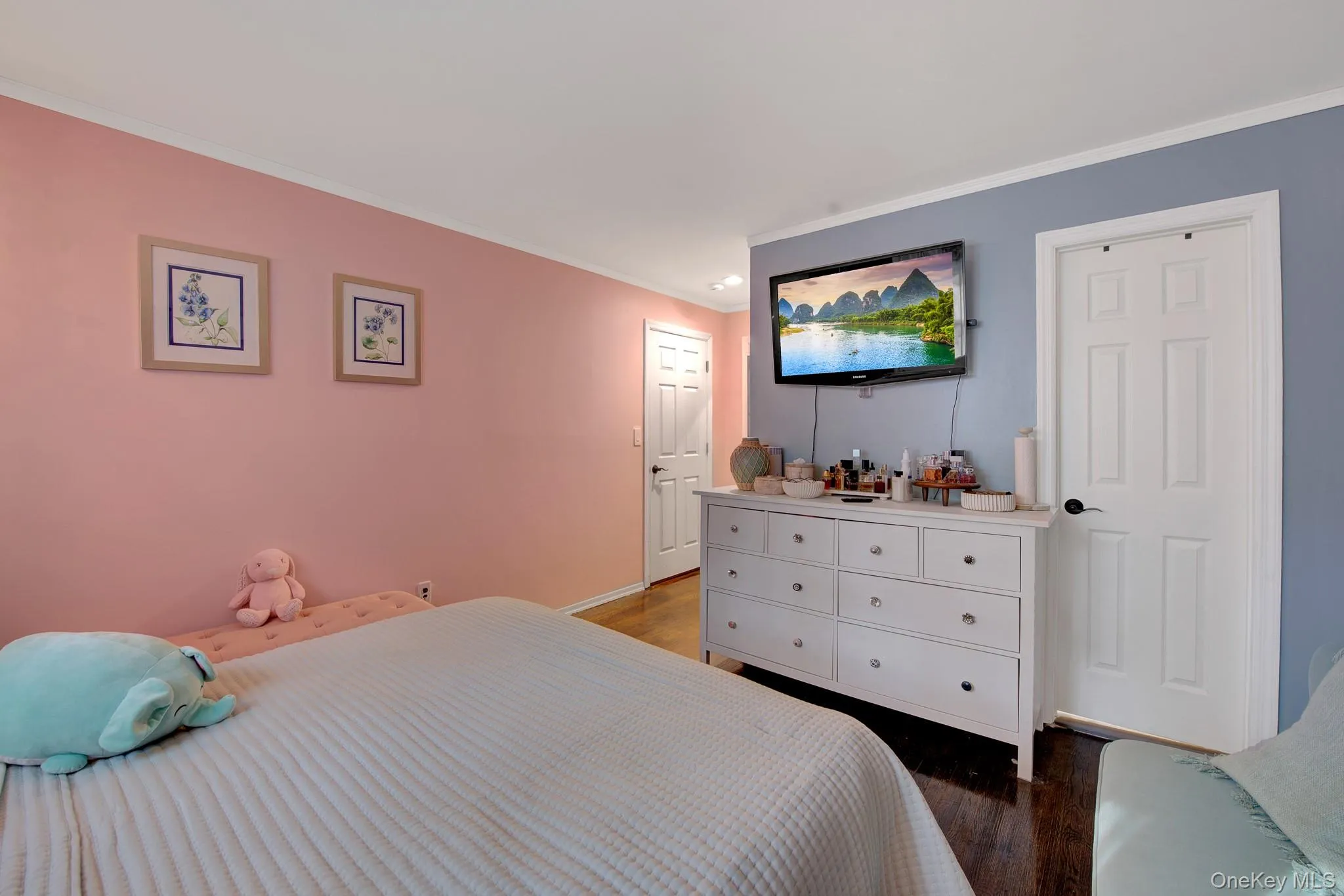 Room featuring dark wood-finish flooring, white baseboards, and a white ceiling with crown molding Room featuring dark wood-finish flooring, white baseboards, and a white ceiling with crown molding