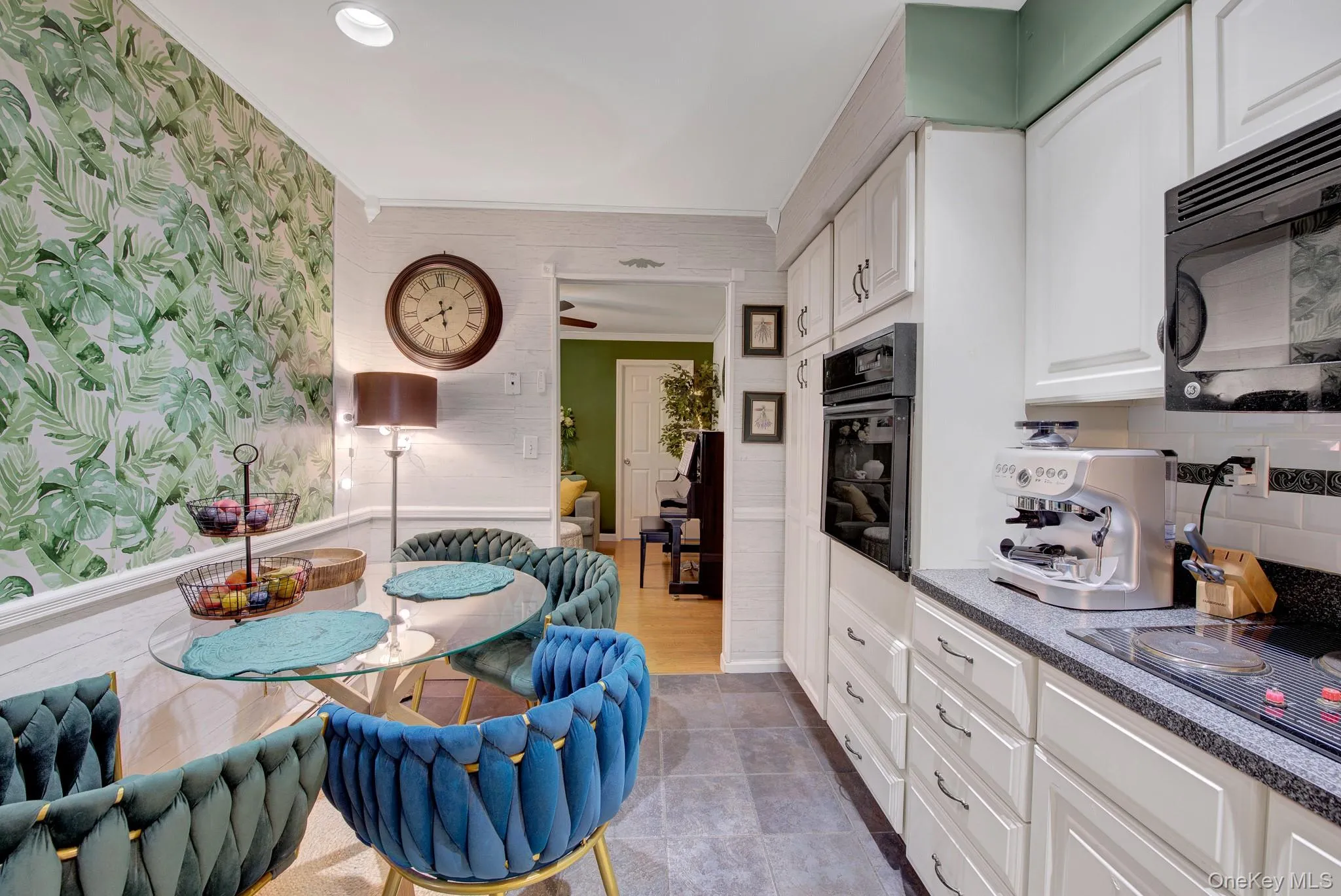 Kitchen featuring white cabinetry, built-in oven, granite-finish countertops, and subway tile backsplash Kitchen featuring white cabinetry, built-in oven, granite-finish countertops, and subway tile backsplash