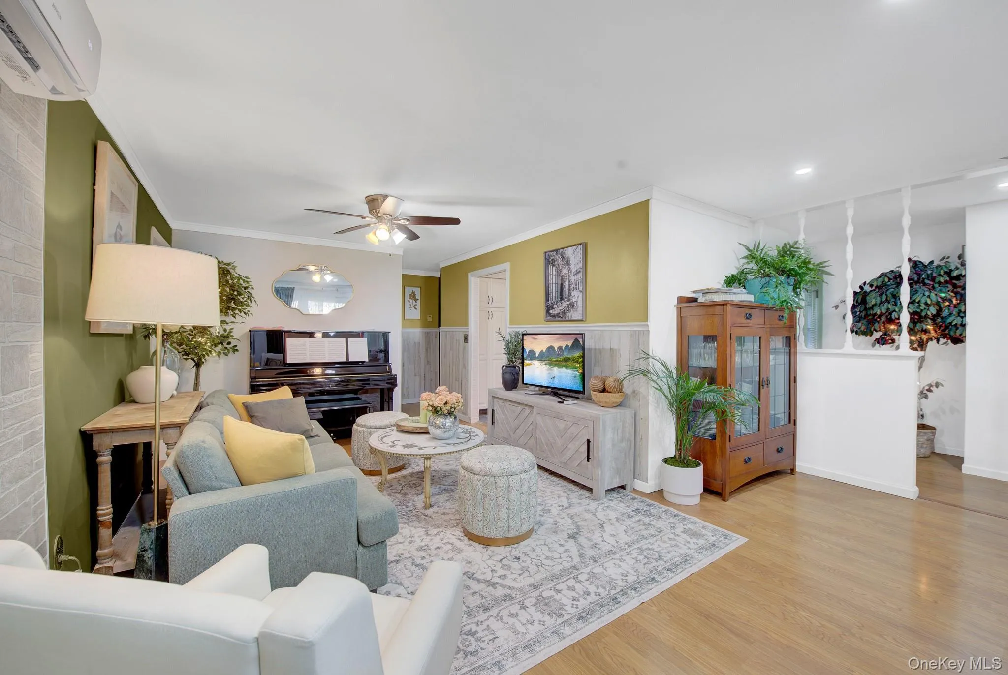 Spacious living area featuring wood-finish flooring, a ceiling fan, and recessed lighting Spacious living area featuring wood-finish flooring, a ceiling fan, and recessed lighting