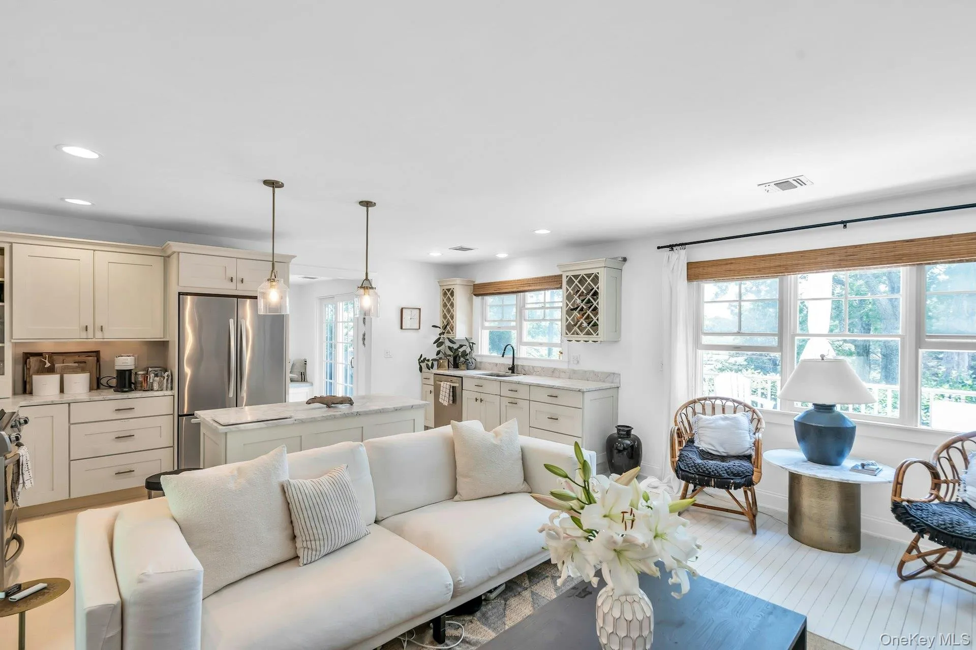 Open-concept living area featuring a kitchen with light cabinetry, stainless steel appliances, and a central island with a countertop Open-concept living area featuring a kitchen with light cabinetry, stainless steel appliances, and a central island with a countertop