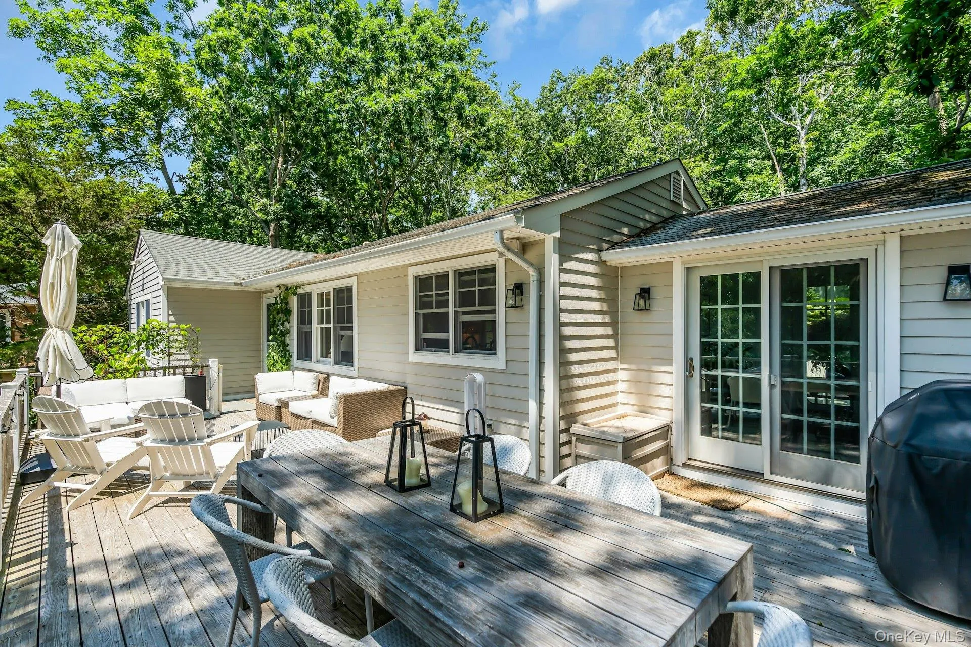 Expansive deck with water views, dining table and BBQ, couches Expansive deck with water views, dining table and BBQ, couches