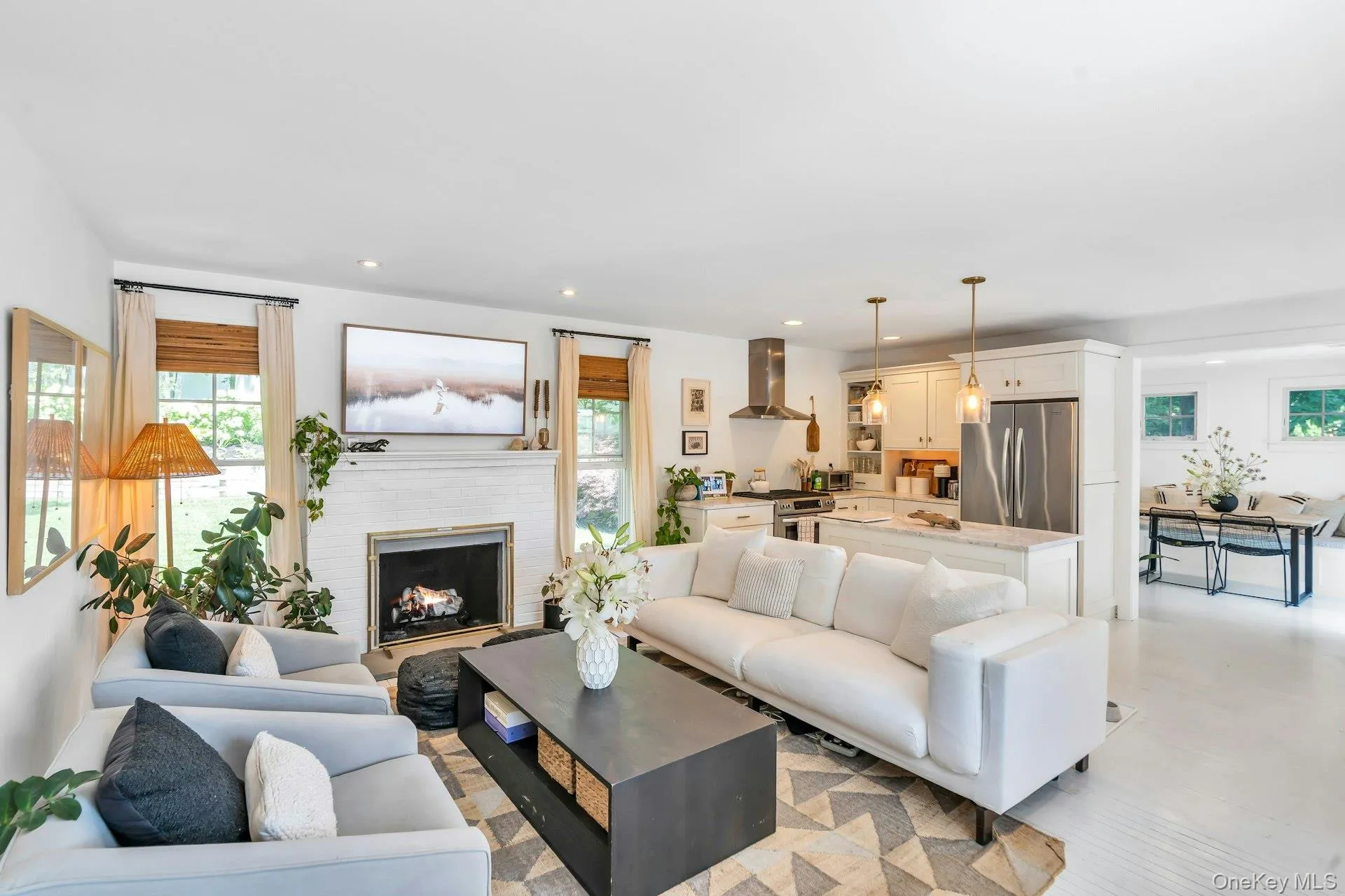 Bright living area featuring a white brick fireplace with a dark metal firebox Bright living area featuring a white brick fireplace with a dark metal firebox