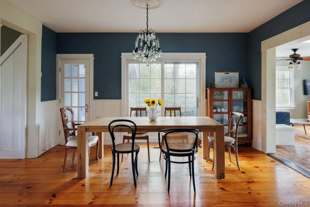 Dining space featuring a chandelier, light wood-style floors, a wainscoted wall, Dining space featuring a chandelier, light wood-style floors, a wainscoted wall,