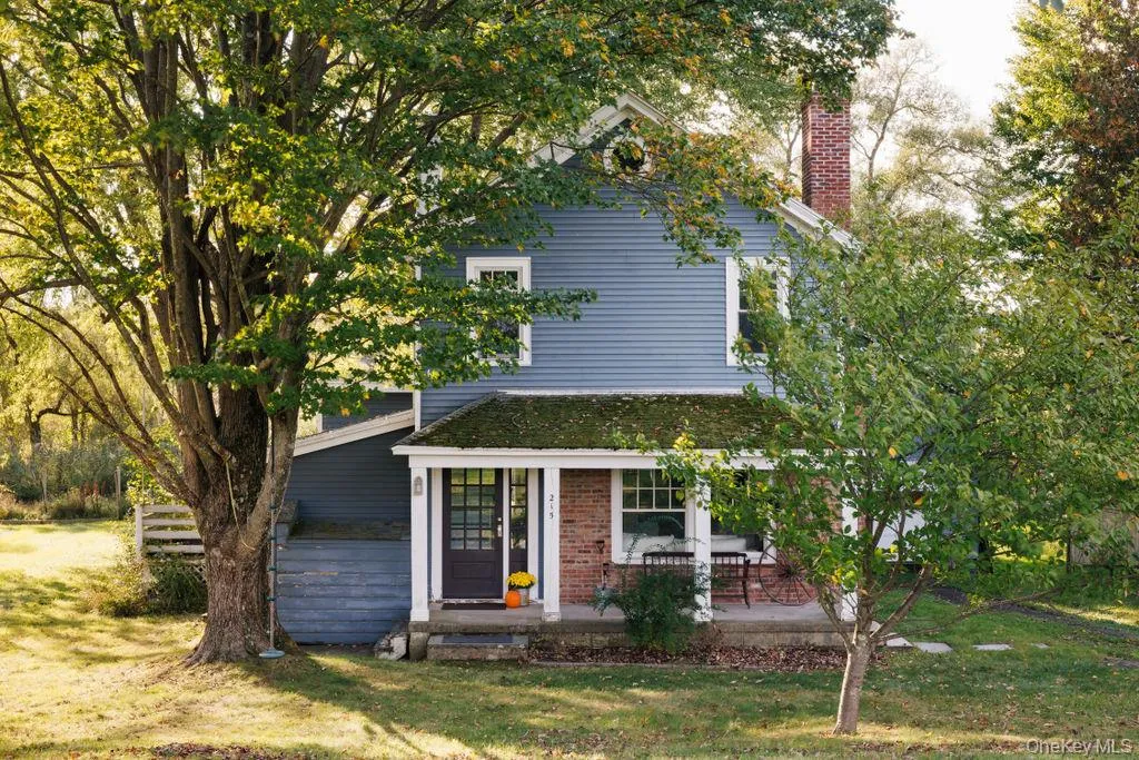 View of property featuring a front lawn, a chimney, and brick siding View of property featuring a front lawn, a chimney, and brick siding