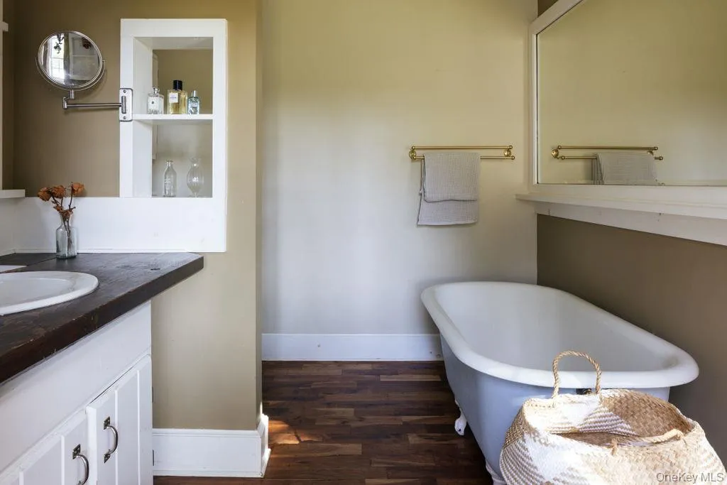 First floor Bathroom with wood finished floors, a freestanding bath, and vanity First floor Bathroom with wood finished floors, a freestanding bath, and vanity