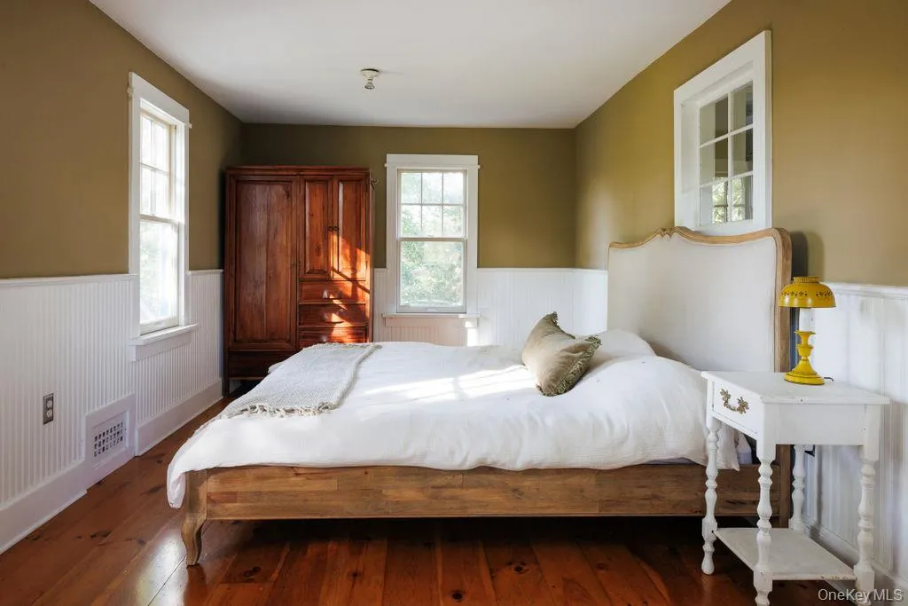Bedroom with wood-type flooring and wainscoting Bedroom with wood-type flooring and wainscoting