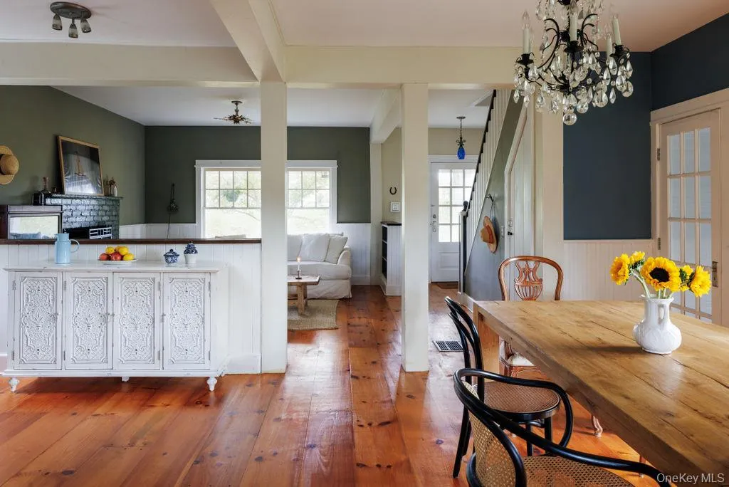 Dining area featuring hardwood / wood-style floors, a wainscoted wall, and a chandelier Dining area featuring hardwood / wood-style floors, a wainscoted wall, and a chandelier
