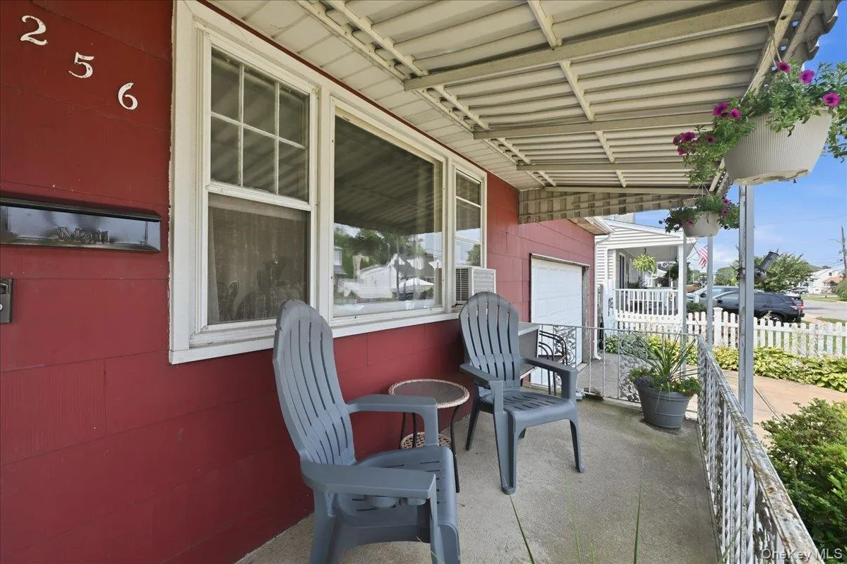 Covered front porch with concrete flooring and white railing Covered front porch with concrete flooring and white railing