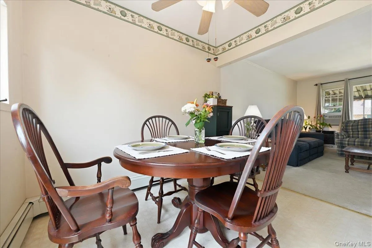 Dining area with an overhead ceiling fan, decorative border trim, and light beige wall tones Dining area with an overhead ceiling fan, decorative border trim, and light beige wall tones