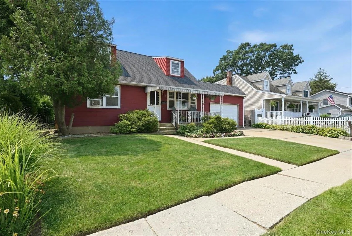 Red siding home featuring a dormer window, covered front entry, and an attached single-car garage Red siding home featuring a dormer window, covered front entry, and an attached single-car garage