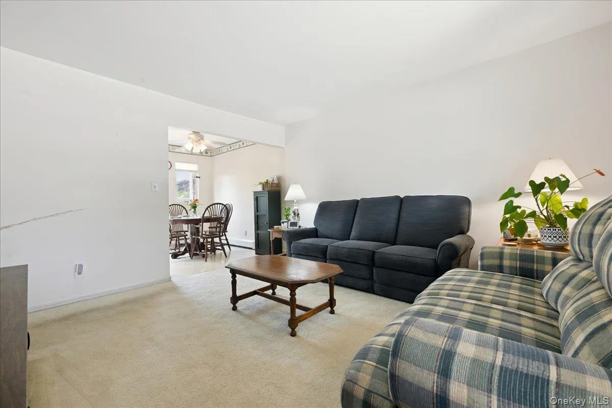 Open-concept living area with neutral carpeting and white walls Open-concept living area with neutral carpeting and white walls