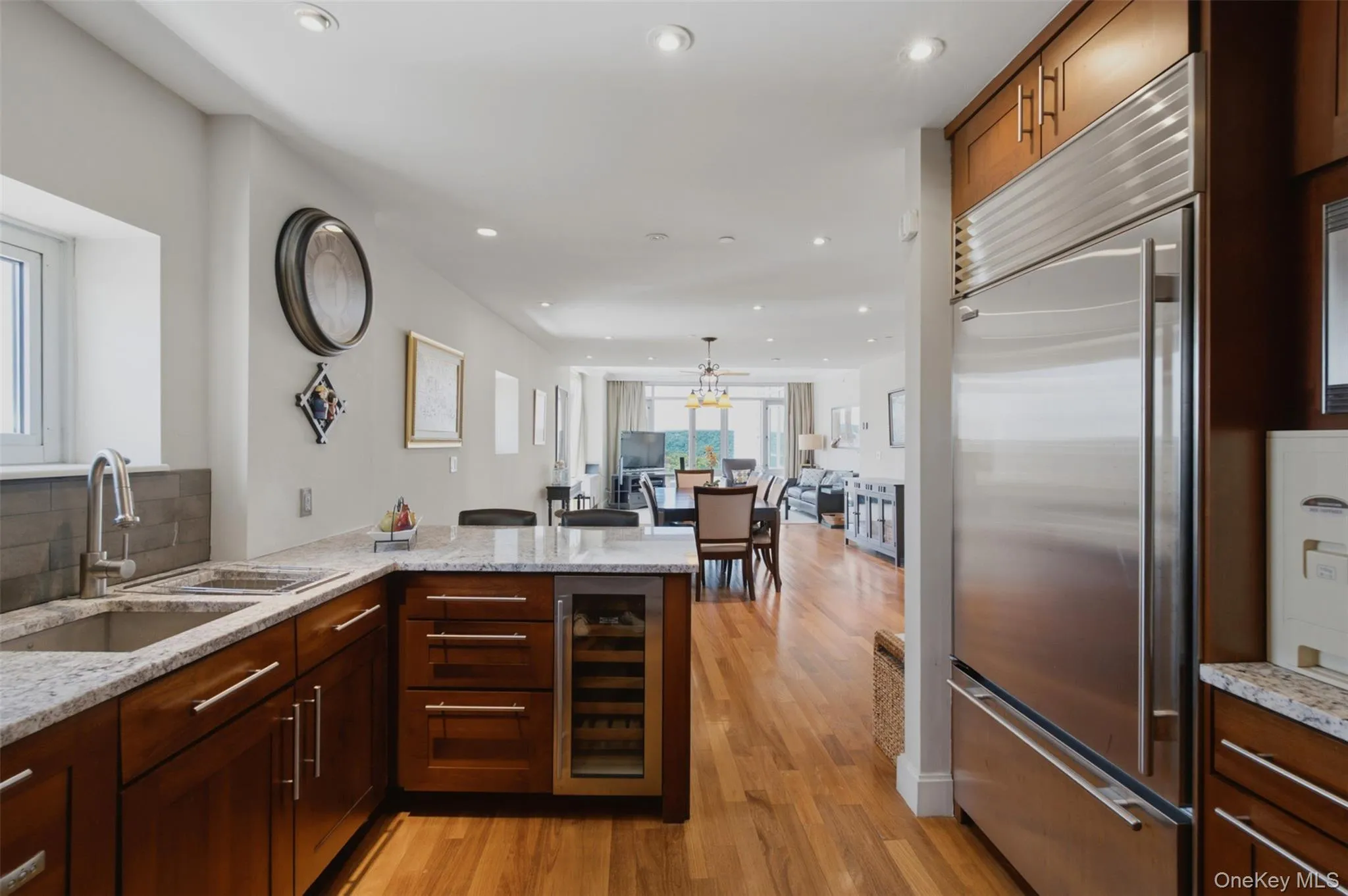 Kitchen featuring wood cabinetry, stainless steel appliances, granite countertops, and hardwood flooring Kitchen featuring wood cabinetry, stainless steel appliances, granite countertops, and hardwood flooring