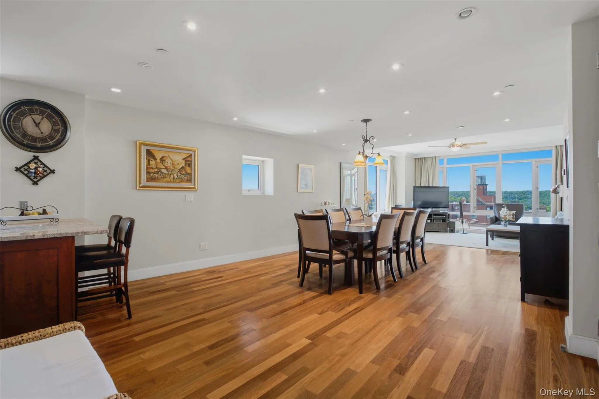Spacious open-concept living area featuring wood-finish flooring and recessed lighting Spacious open-concept living area featuring wood-finish flooring and recessed lighting