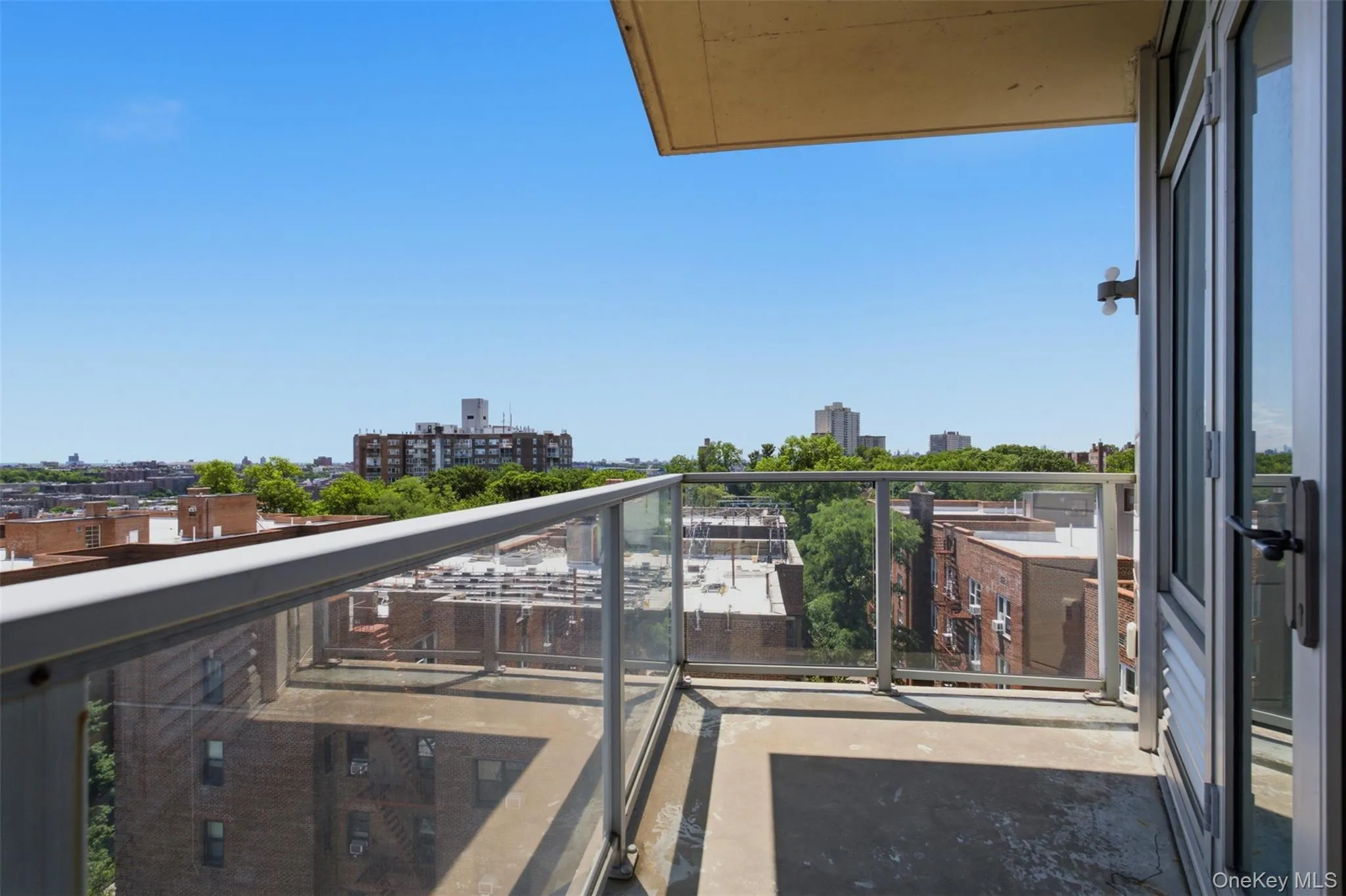 Private balcony with a concrete floor, glass railing, and aluminum frame Private balcony with a concrete floor, glass railing, and aluminum frame