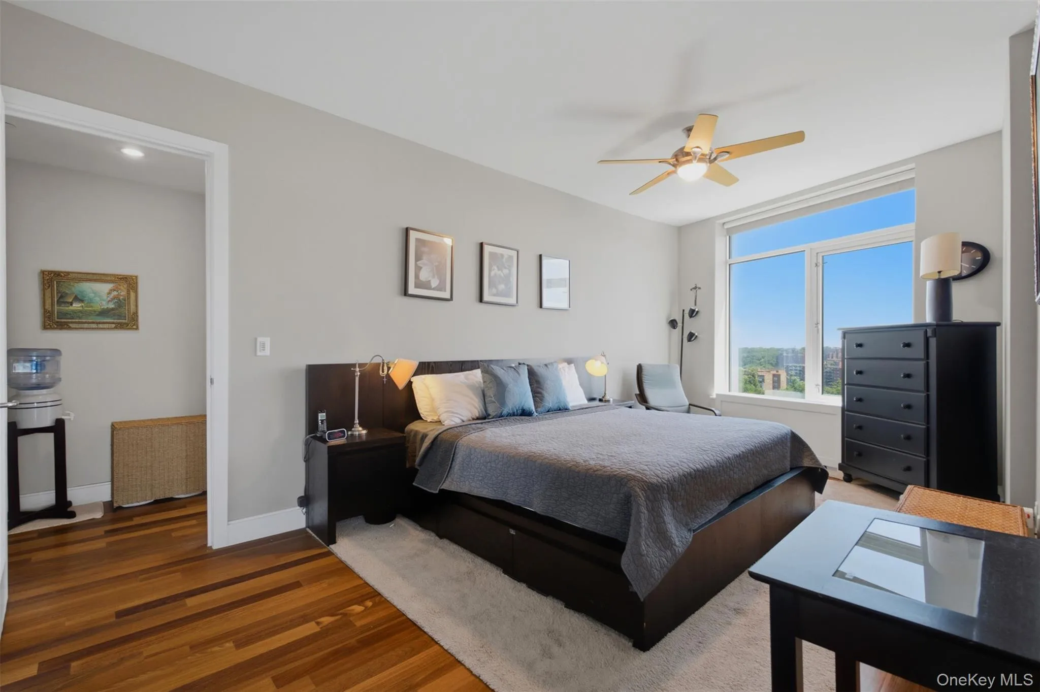 Bedroom 2 with expansive windows illuminate the room, complemented by a ceiling fan with integrated lighting Bedroom 2 with expansive windows illuminate the room, complemented by a ceiling fan with integrated lighting