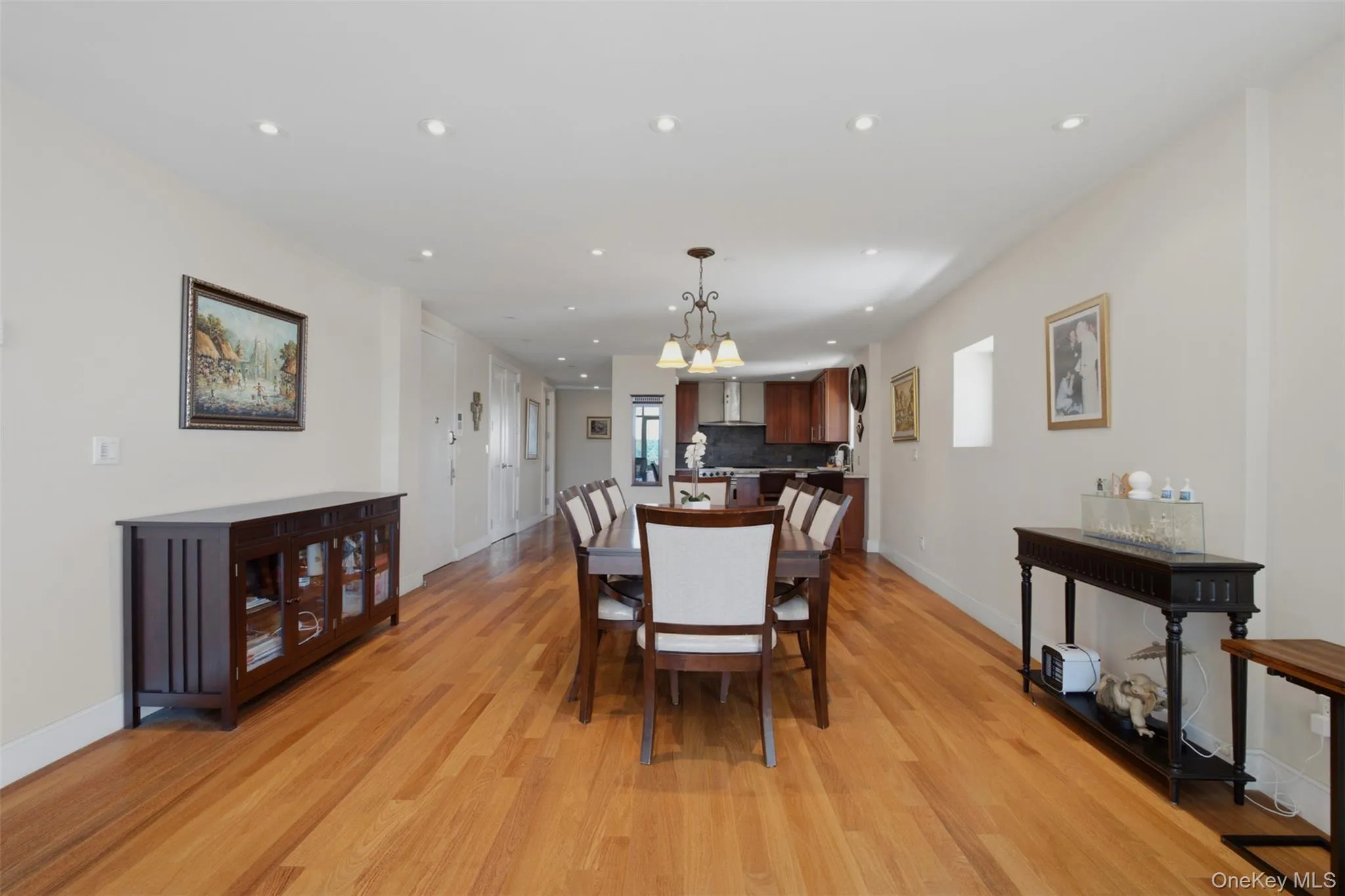 Open-concept dining area featuring wood-finish flooring, recessed lighting, and a chandelier Open-concept dining area featuring wood-finish flooring, recessed lighting, and a chandelier