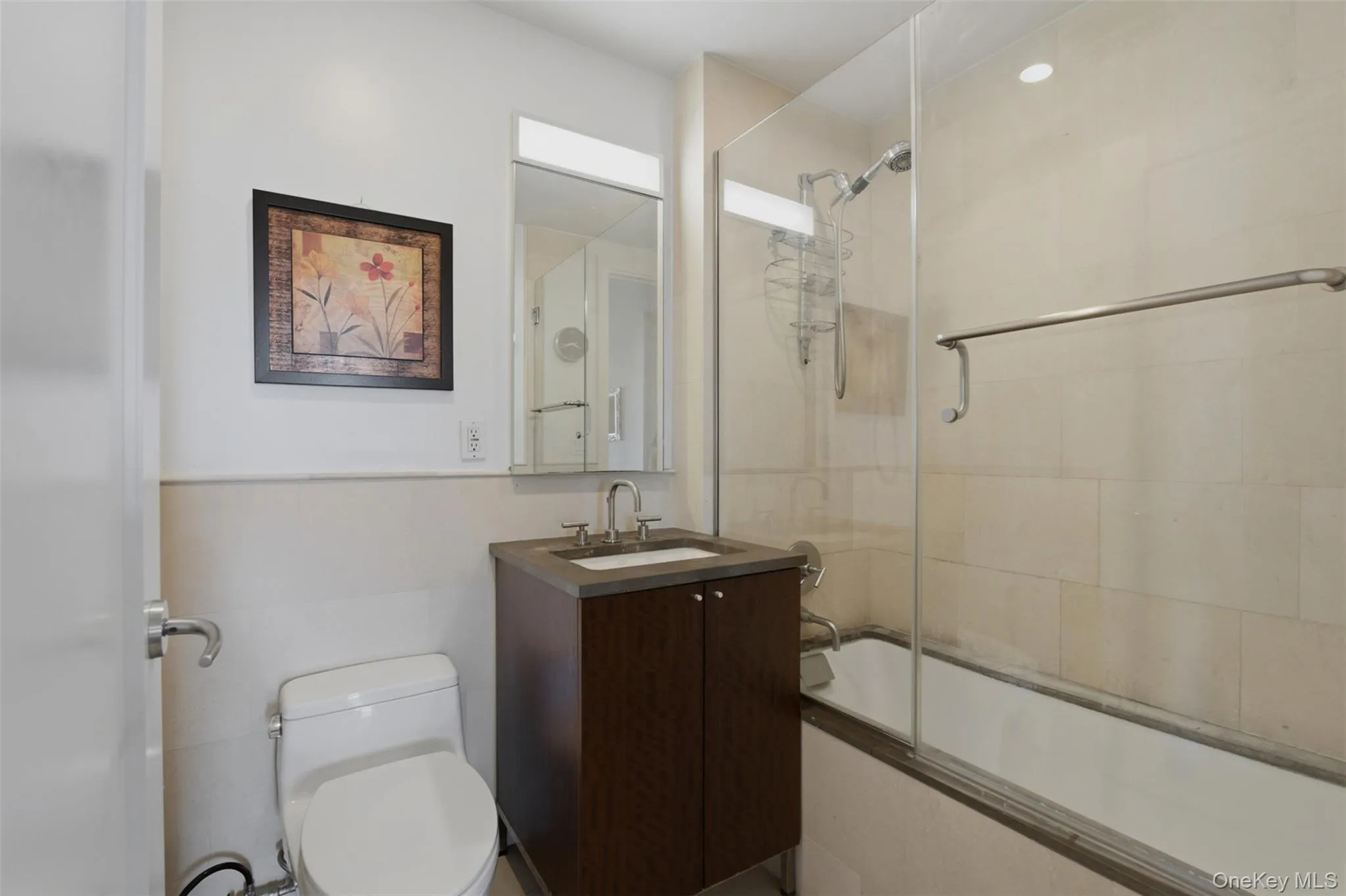 Bathroom featuring a dark wood-finish vanity with a single basin sink and wall-mounted mirror Bathroom featuring a dark wood-finish vanity with a single basin sink and wall-mounted mirror