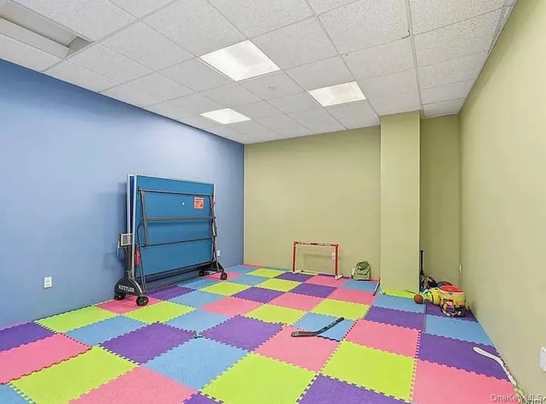 Recreational room featuring colorful interlocking floor mats and a drop ceiling with integrated lighting Recreational room featuring colorful interlocking floor mats and a drop ceiling with integrated lighting