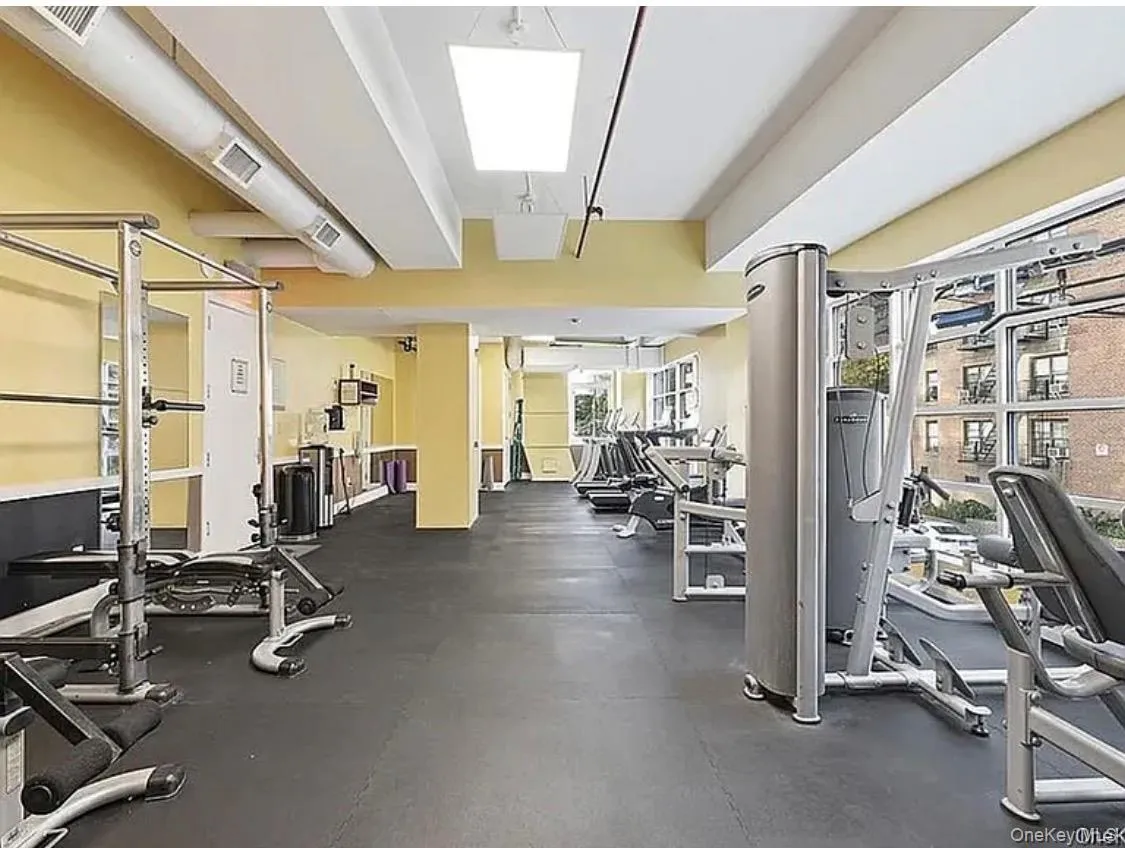 Expansive fitness center featuring commercial-grade equipment, rubberized flooring, and large windows Expansive fitness center featuring commercial-grade equipment, rubberized flooring, and large windows