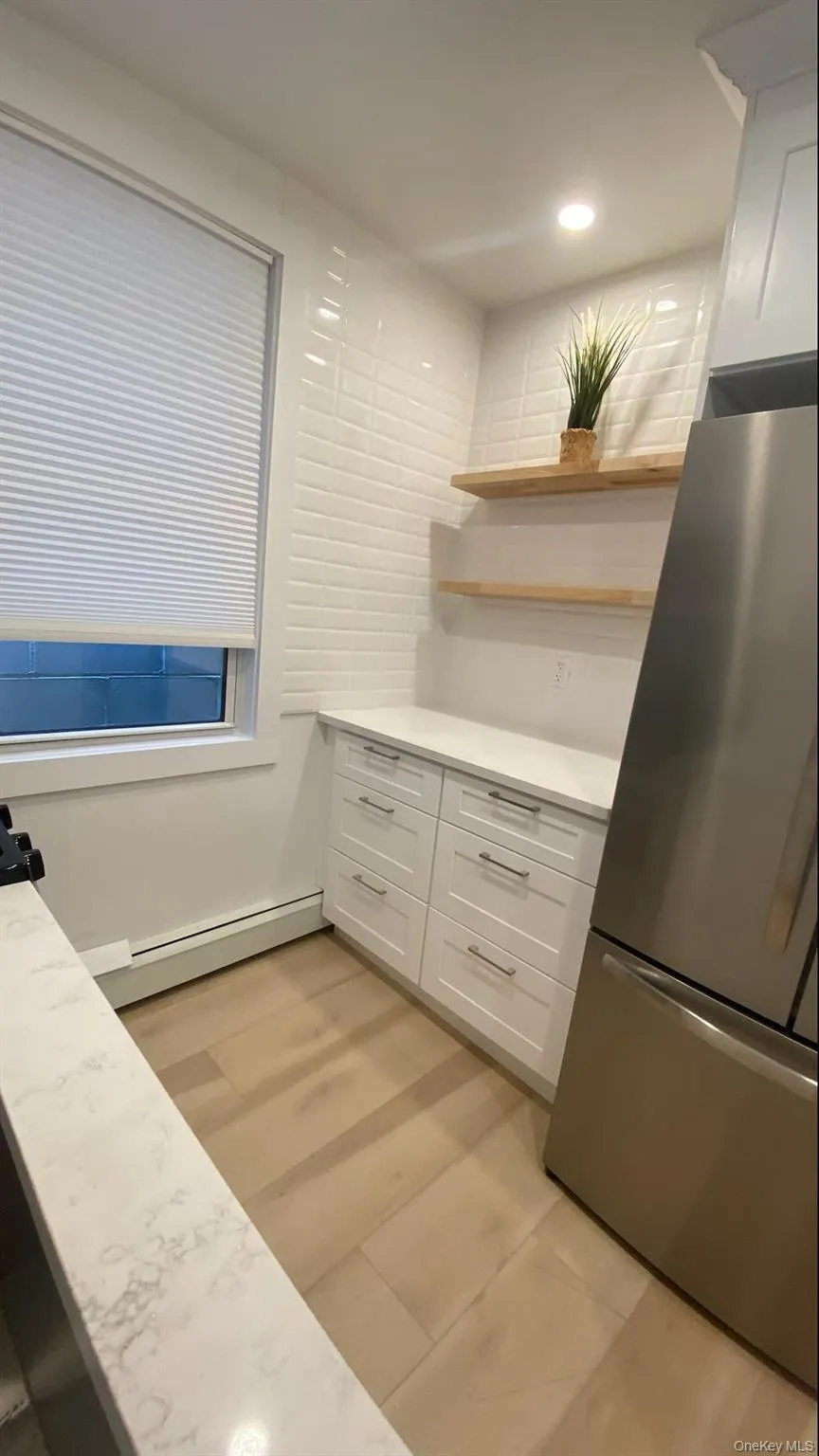 Kitchen with open shelves, white cabinets, stainless steel appliances and recessed lighting Kitchen with open shelves, white cabinets, stainless steel appliances and recessed lighting
