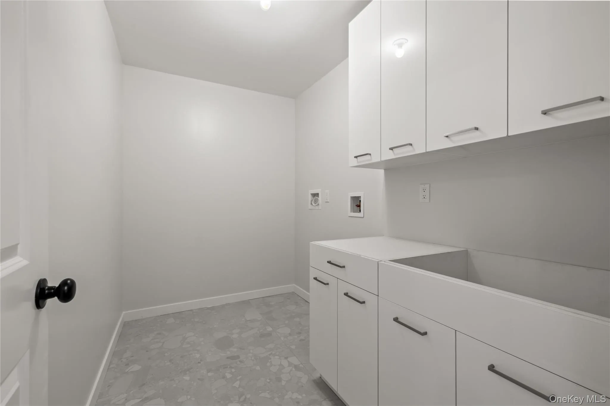 Well-organized laundry room with extensive white cabinets. Well-organized laundry room with extensive white cabinets.