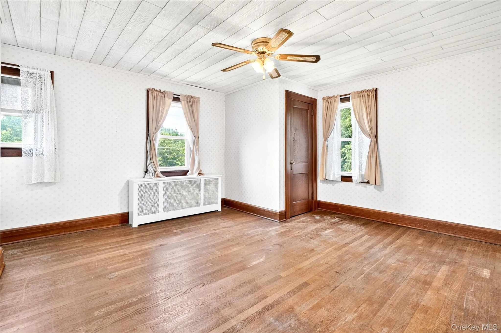Hardwood flooring, paneled ceiling, ceiling fan, wood-frame windows, and a wood-finish door Hardwood flooring, paneled ceiling, ceiling fan, wood-frame windows, and a wood-finish door