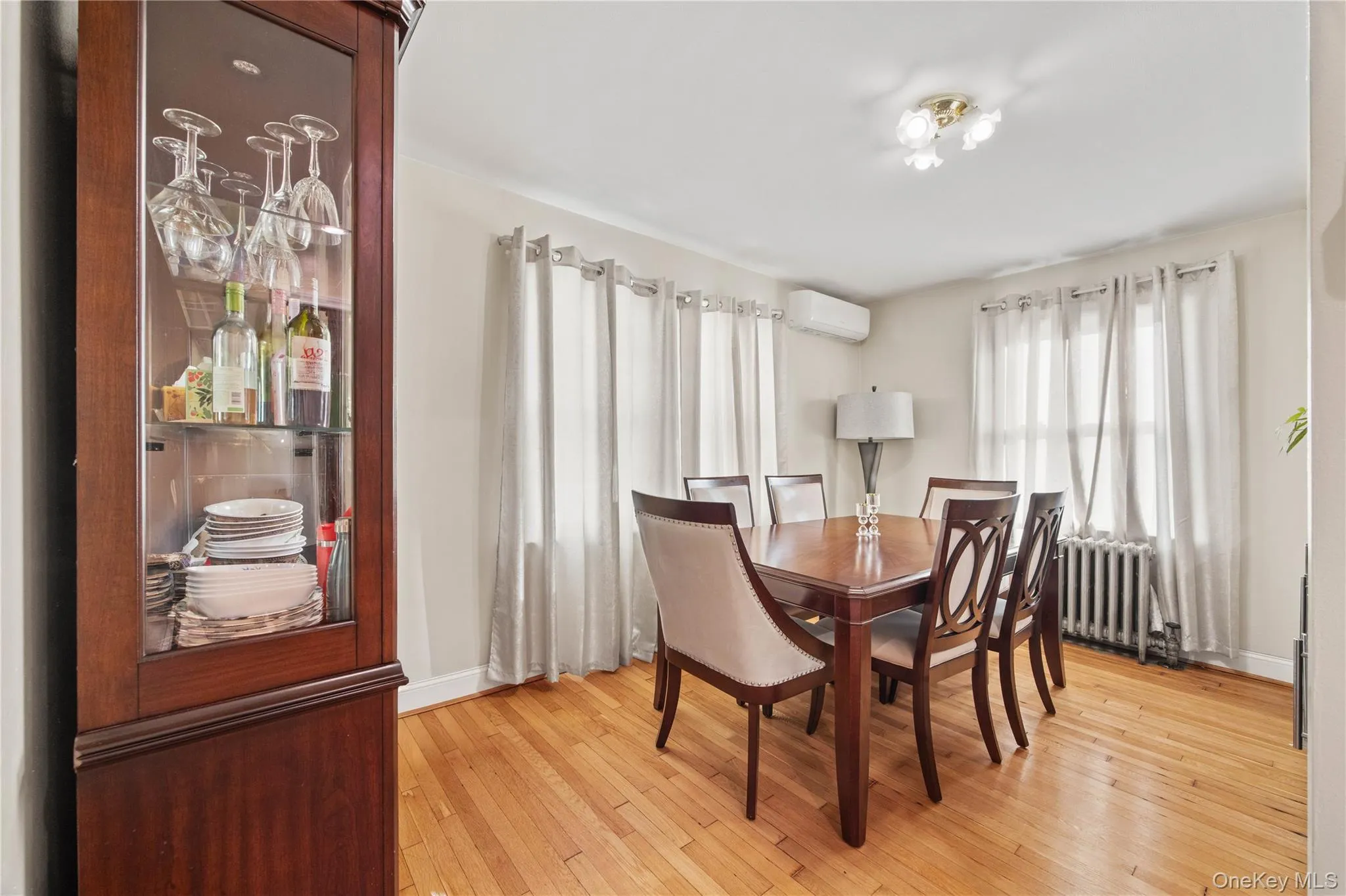 Hardwood flooring throughout, with a built-in corner display cabinet featuring glass shelving Hardwood flooring throughout, with a built-in corner display cabinet featuring glass shelving